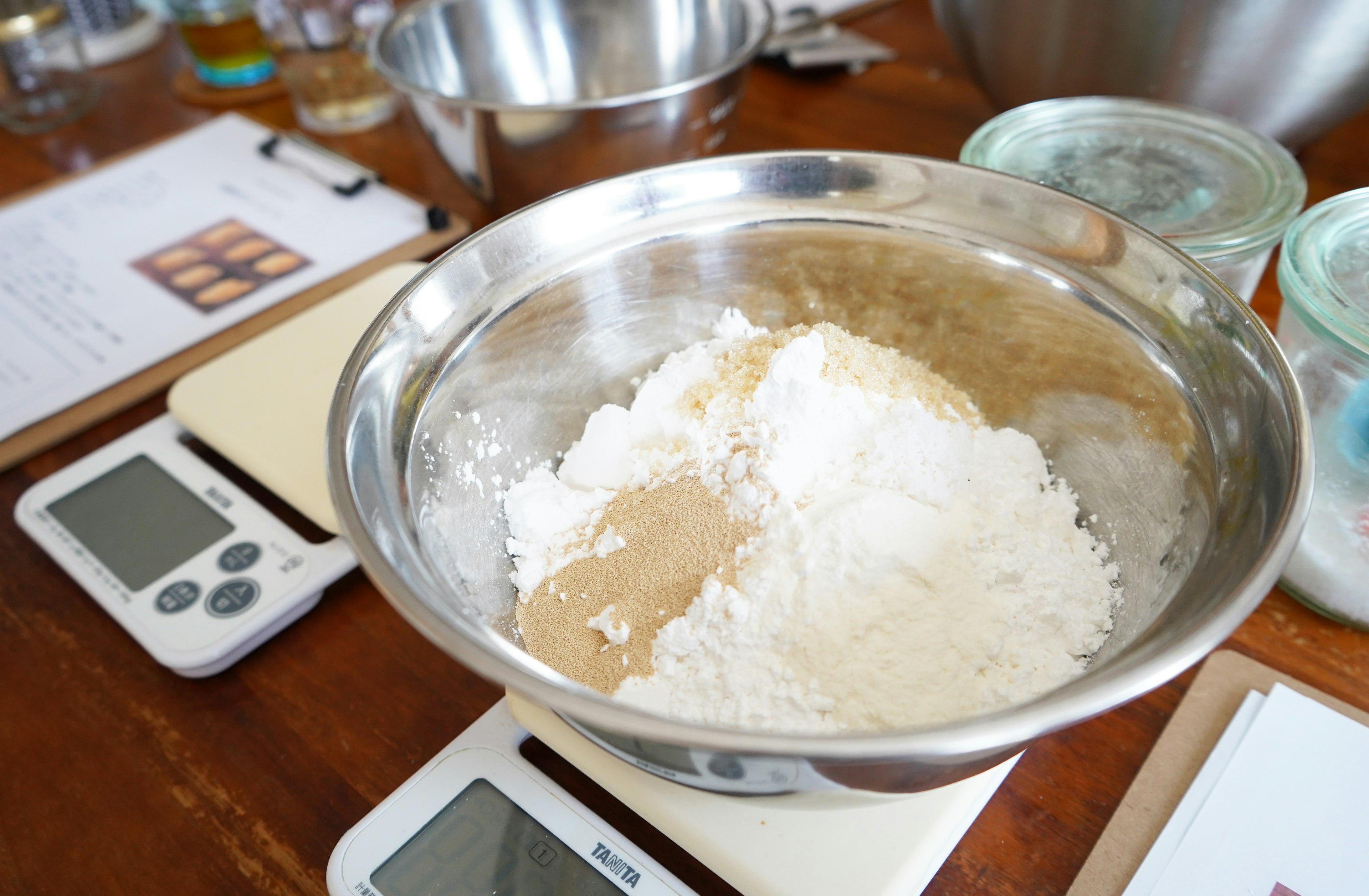 A bowl with measured flour and yeast in a cooking class setting