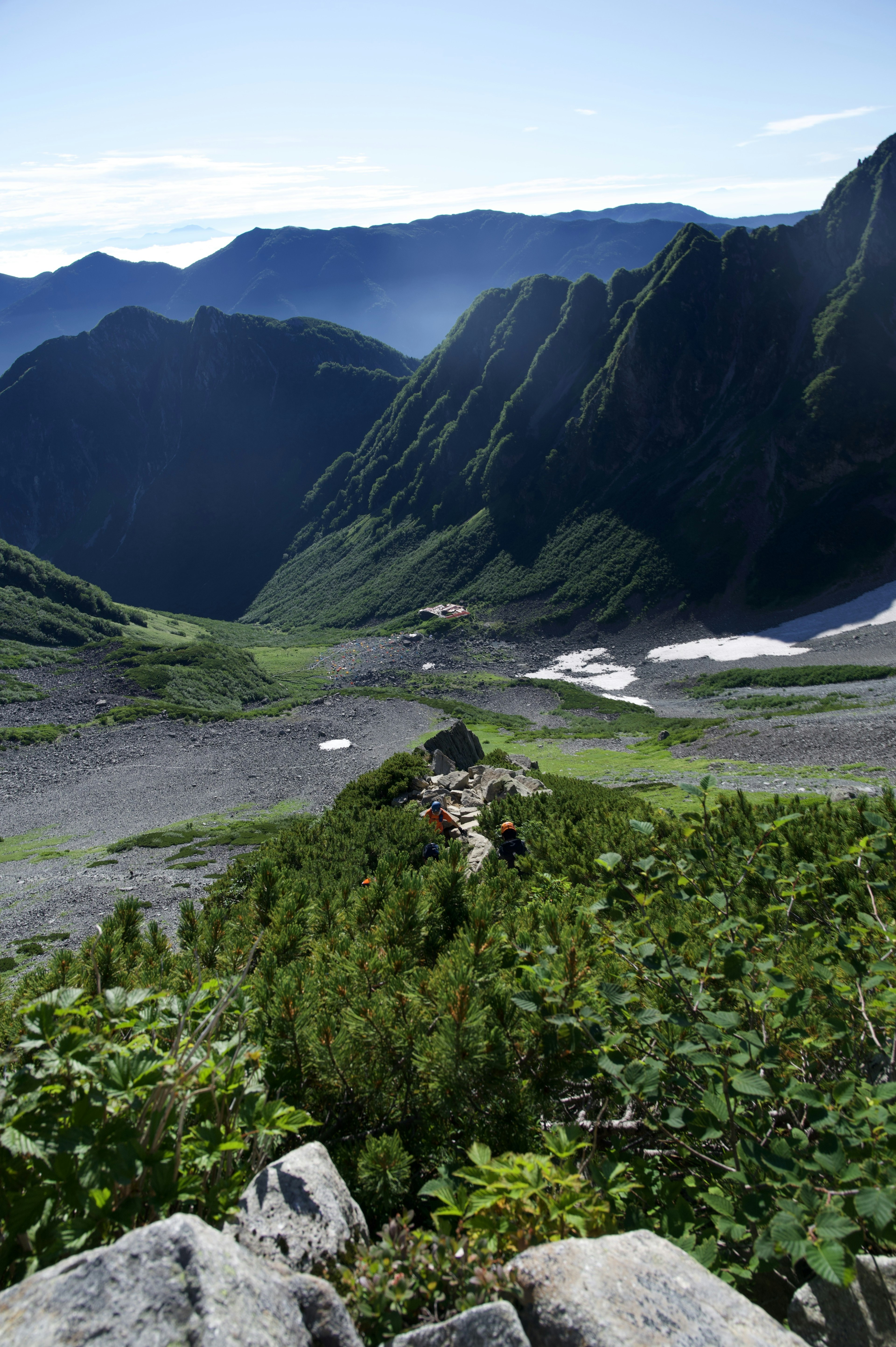 Paysage verdoyant dans une vallée montagneuse avec des montagnes escarpées