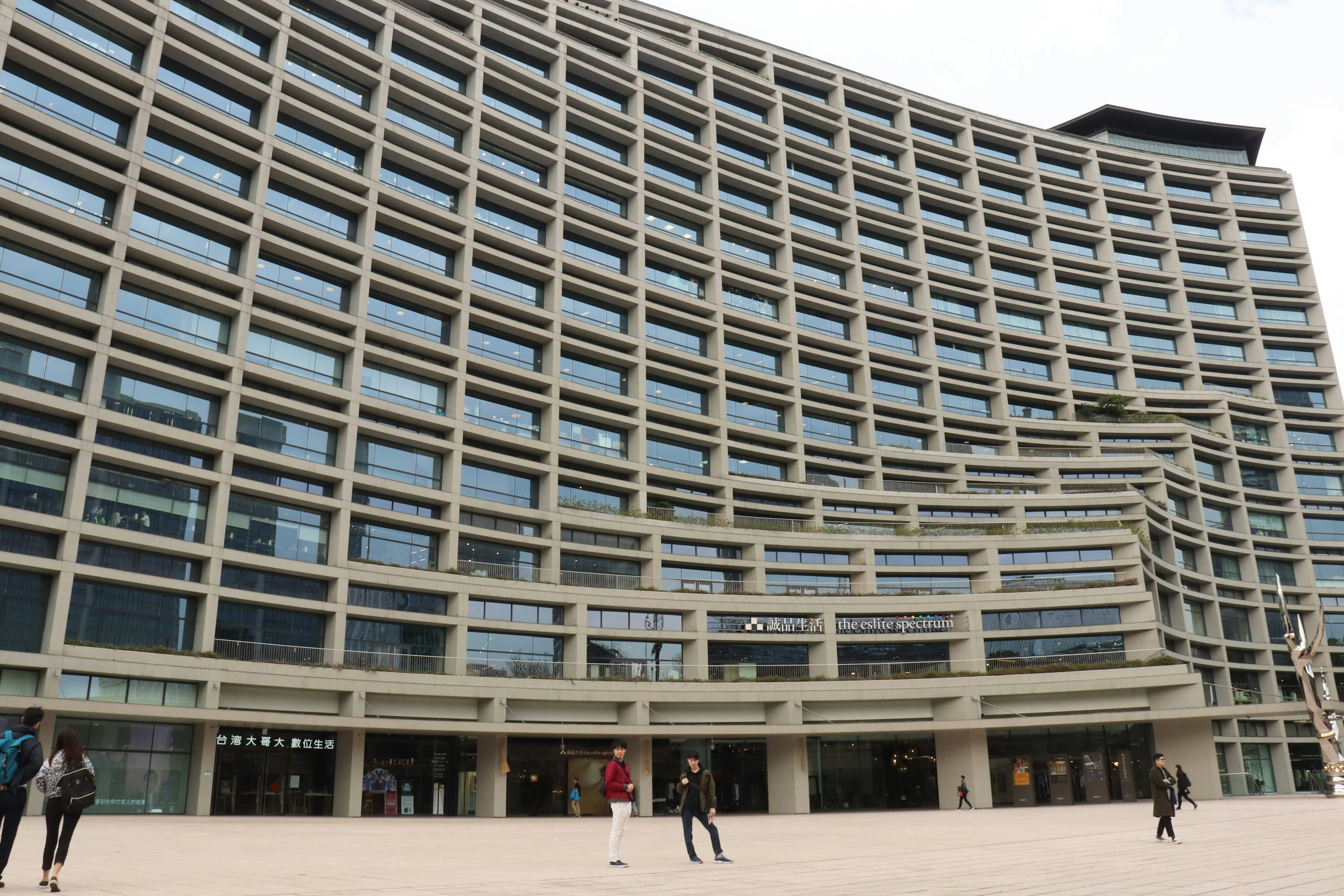 Façade d'un bâtiment moderne avec des personnes marchant