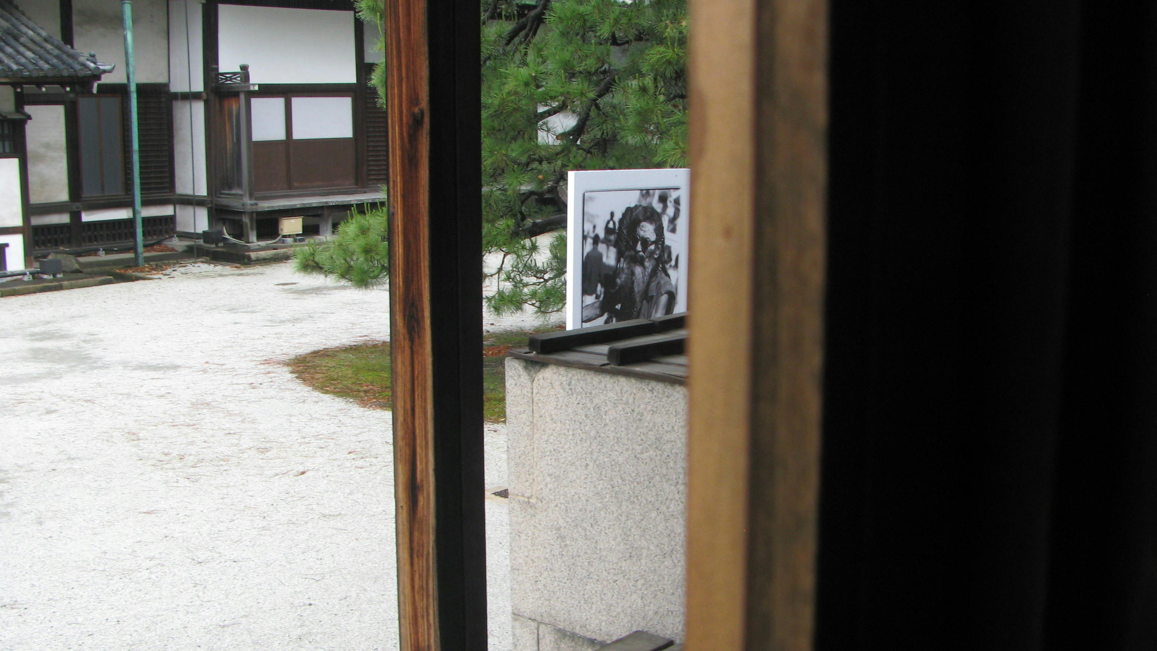 Vista attraverso un telaio di legno che mostra una scena all'aperto con una fotografia in bianco e nero