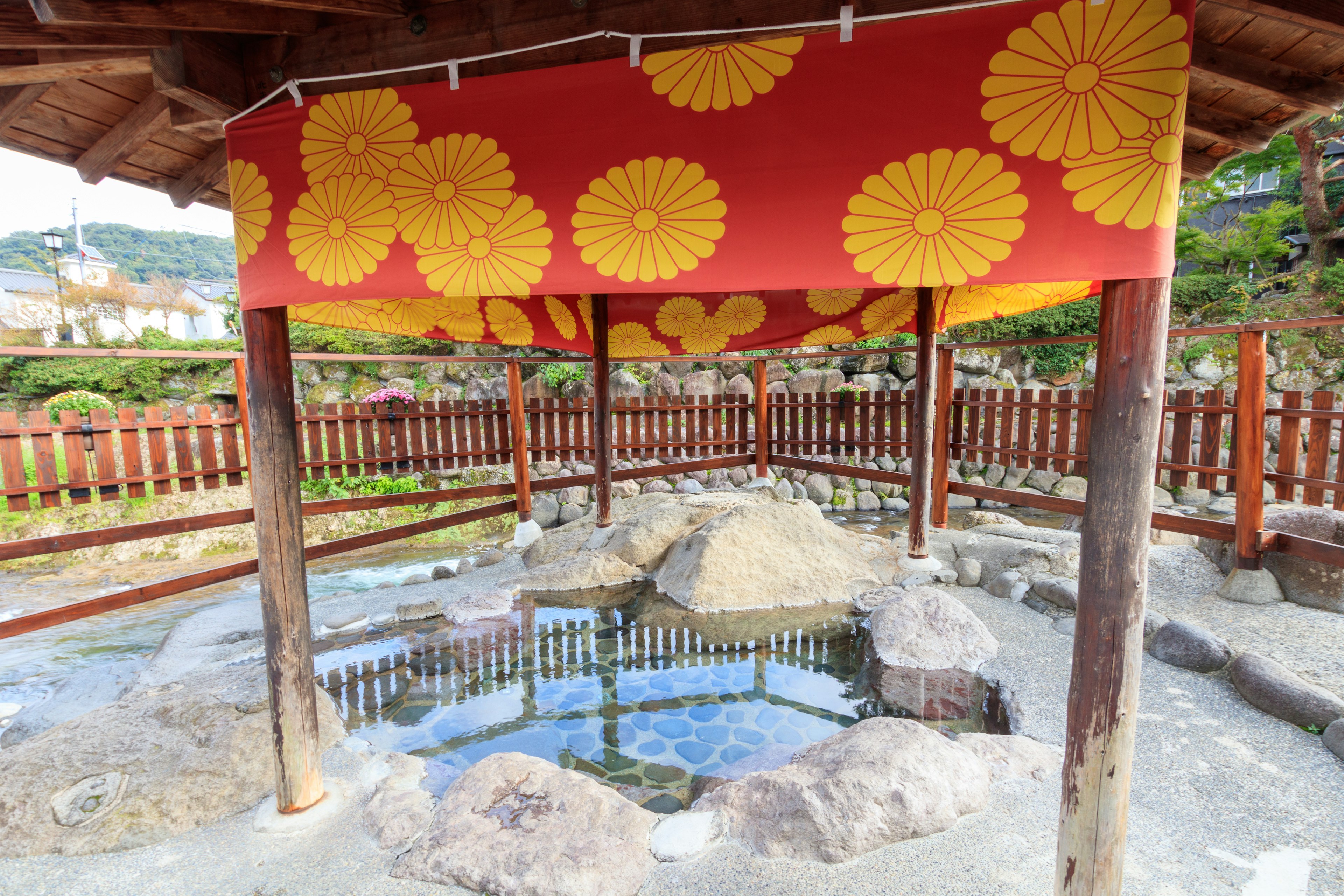 Tienda roja con patrones florales amarillos en un área de descanso de aguas termales