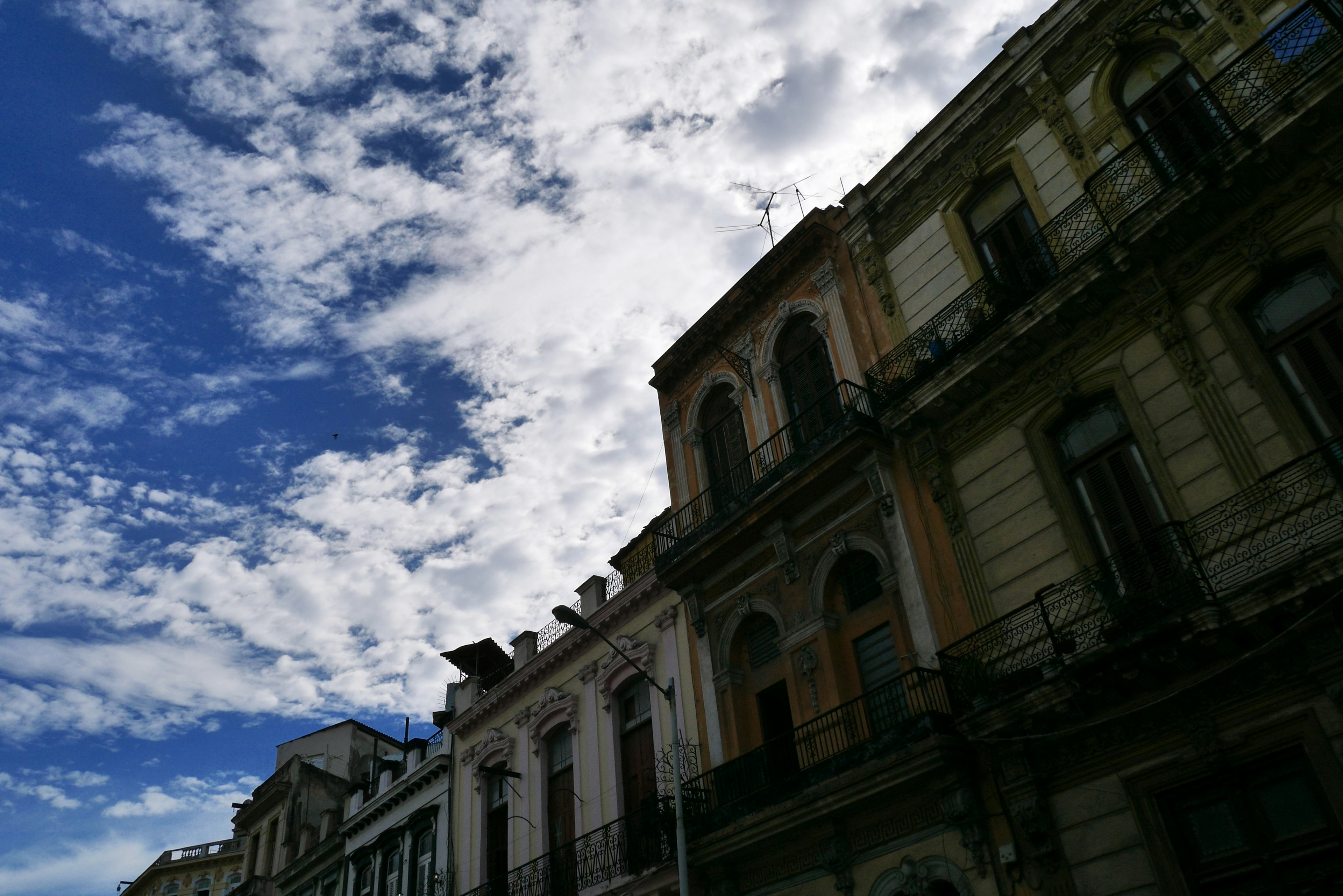 Historic building facades against a backdrop of blue sky and clouds