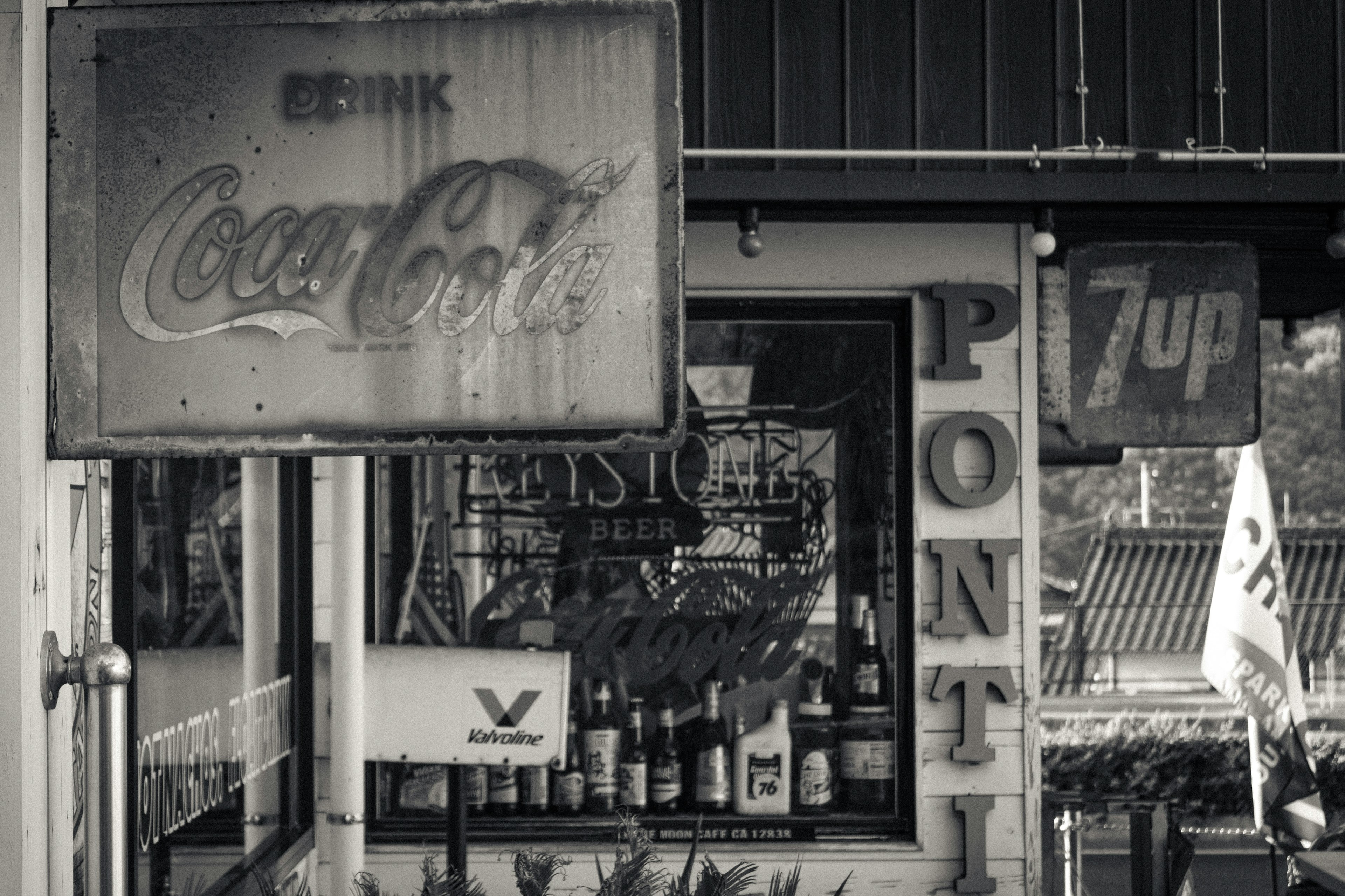 Exterior de una tienda con letreros de Coca-Cola y 7 Up