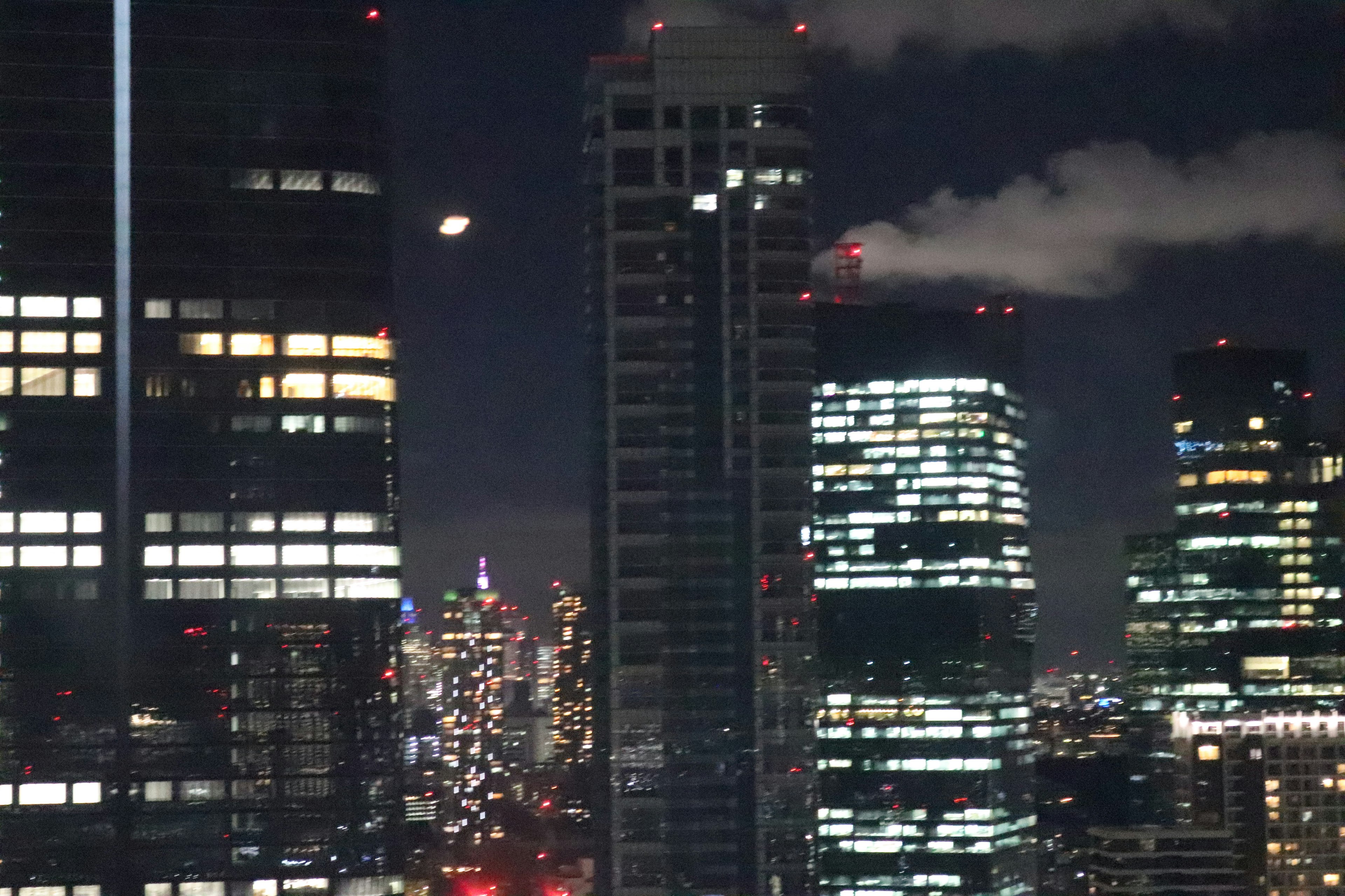 Paesaggio urbano notturno con grattacieli e finestre illuminate