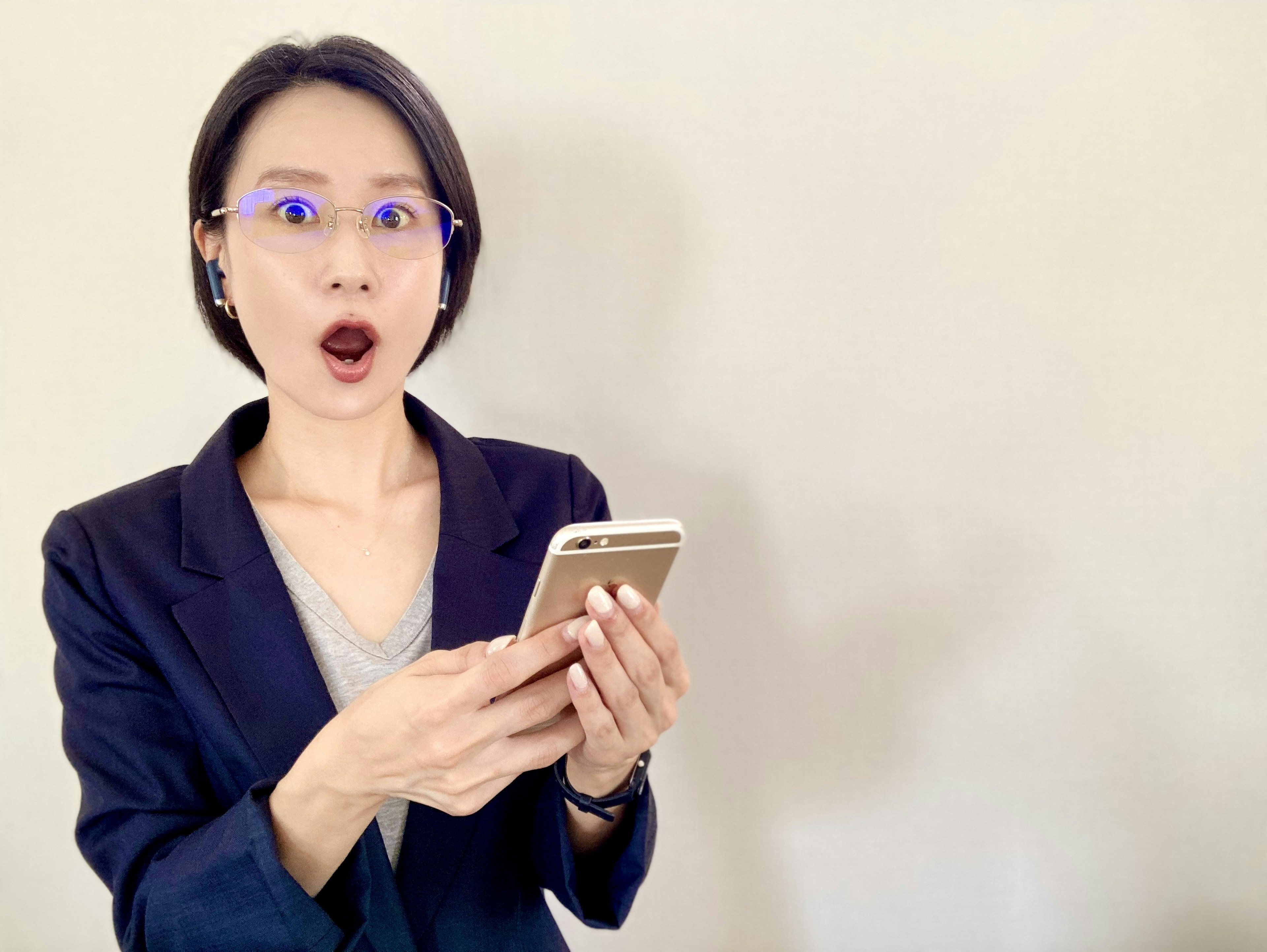 驚いた表情の女性がスマートフォンを持っている