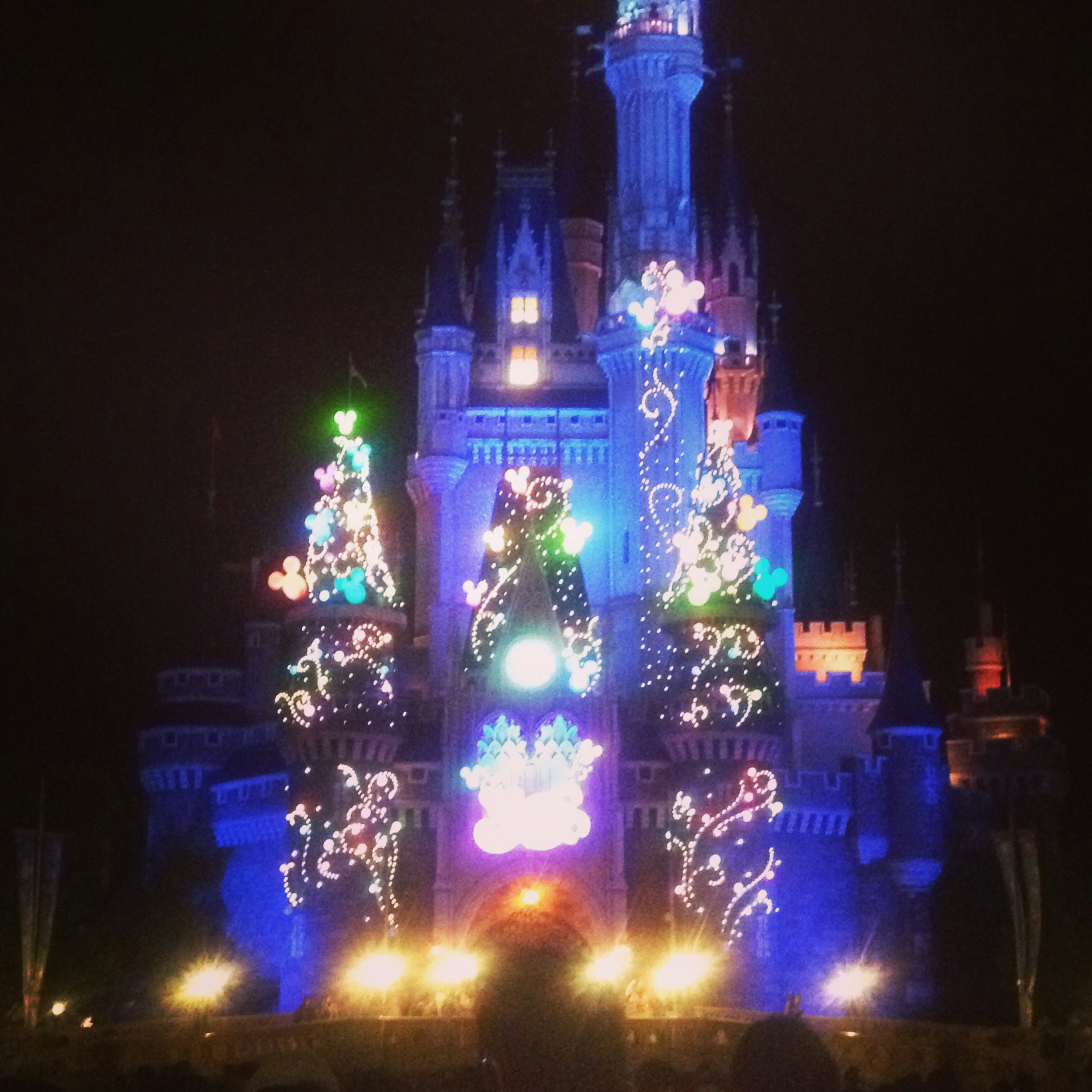 Decoraciones navideñas en un castillo iluminado con luces de colores