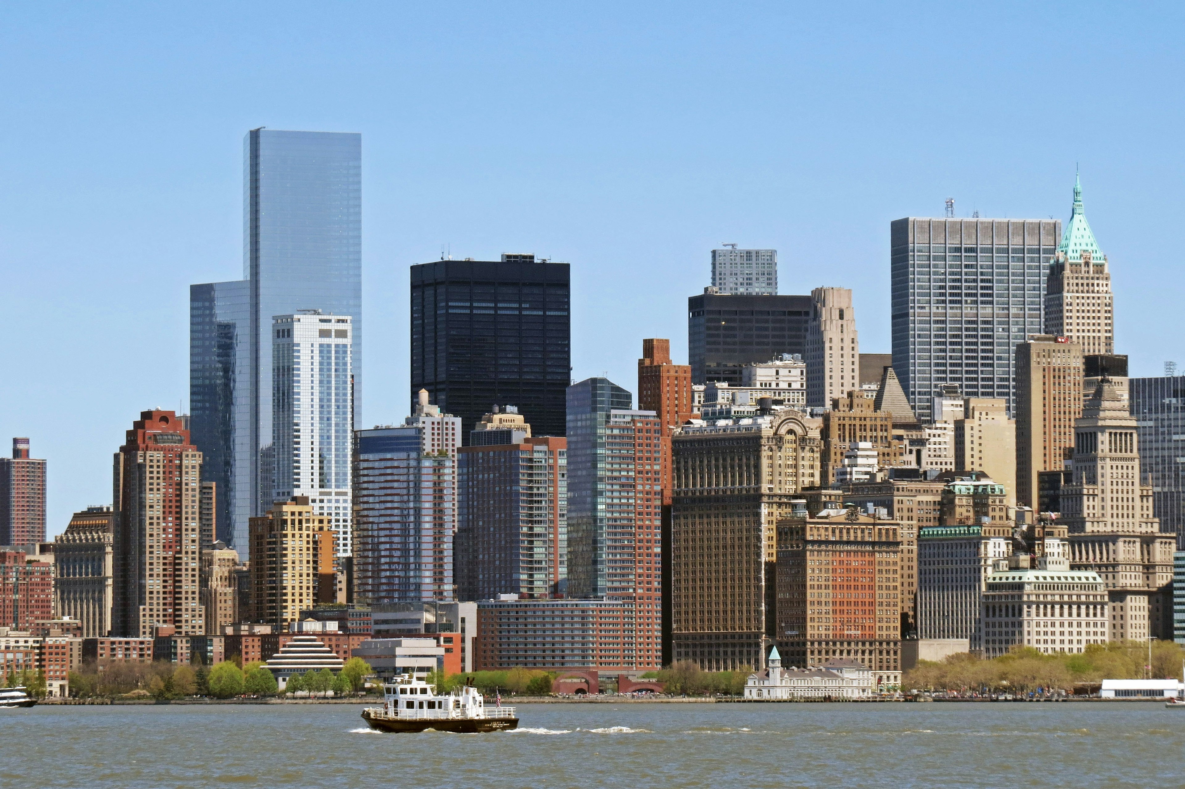 Panoramic view of New York skyscrapers with a boat on the river