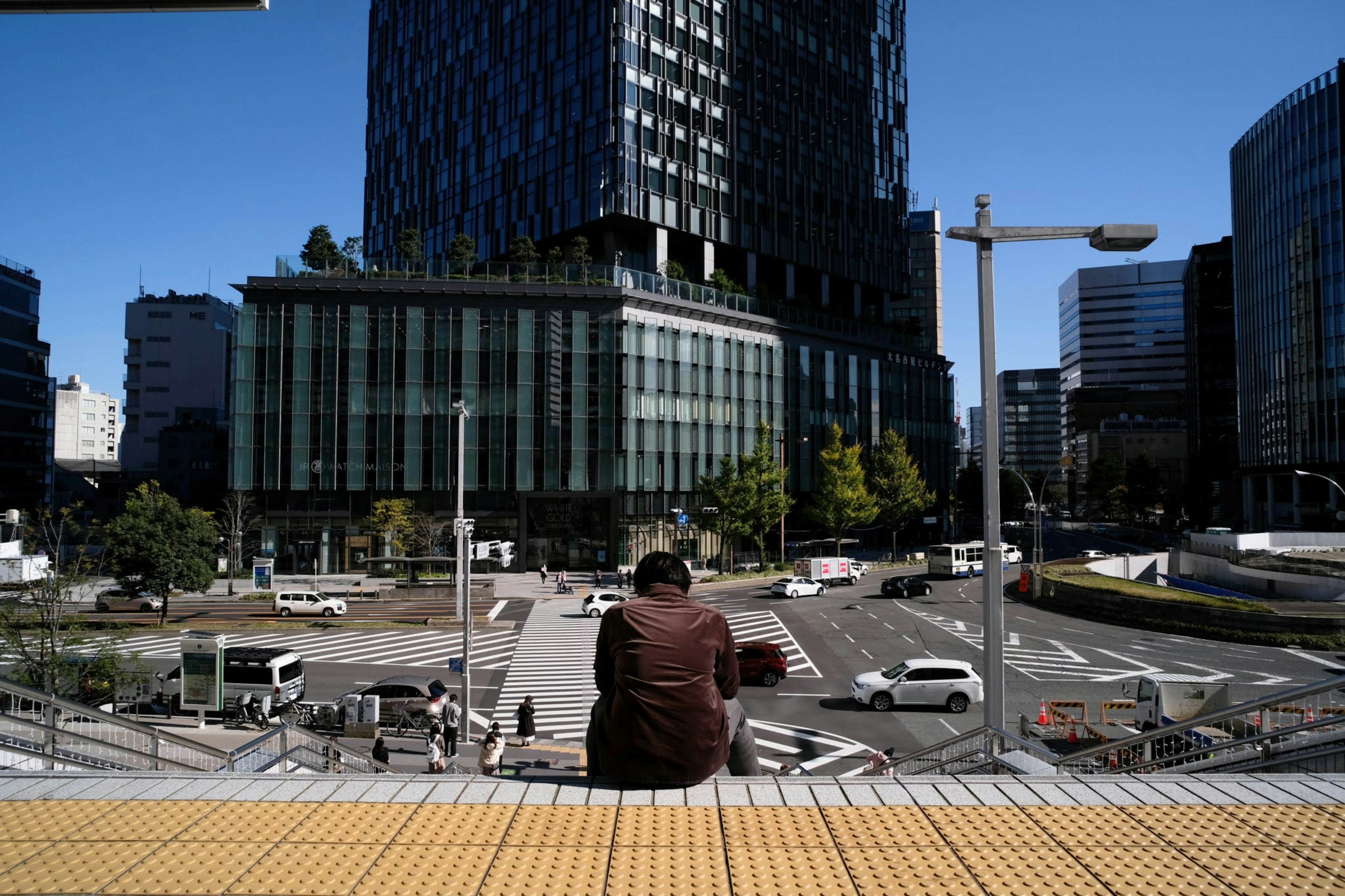 A man gazing at an urban scene featuring tall buildings and traffic