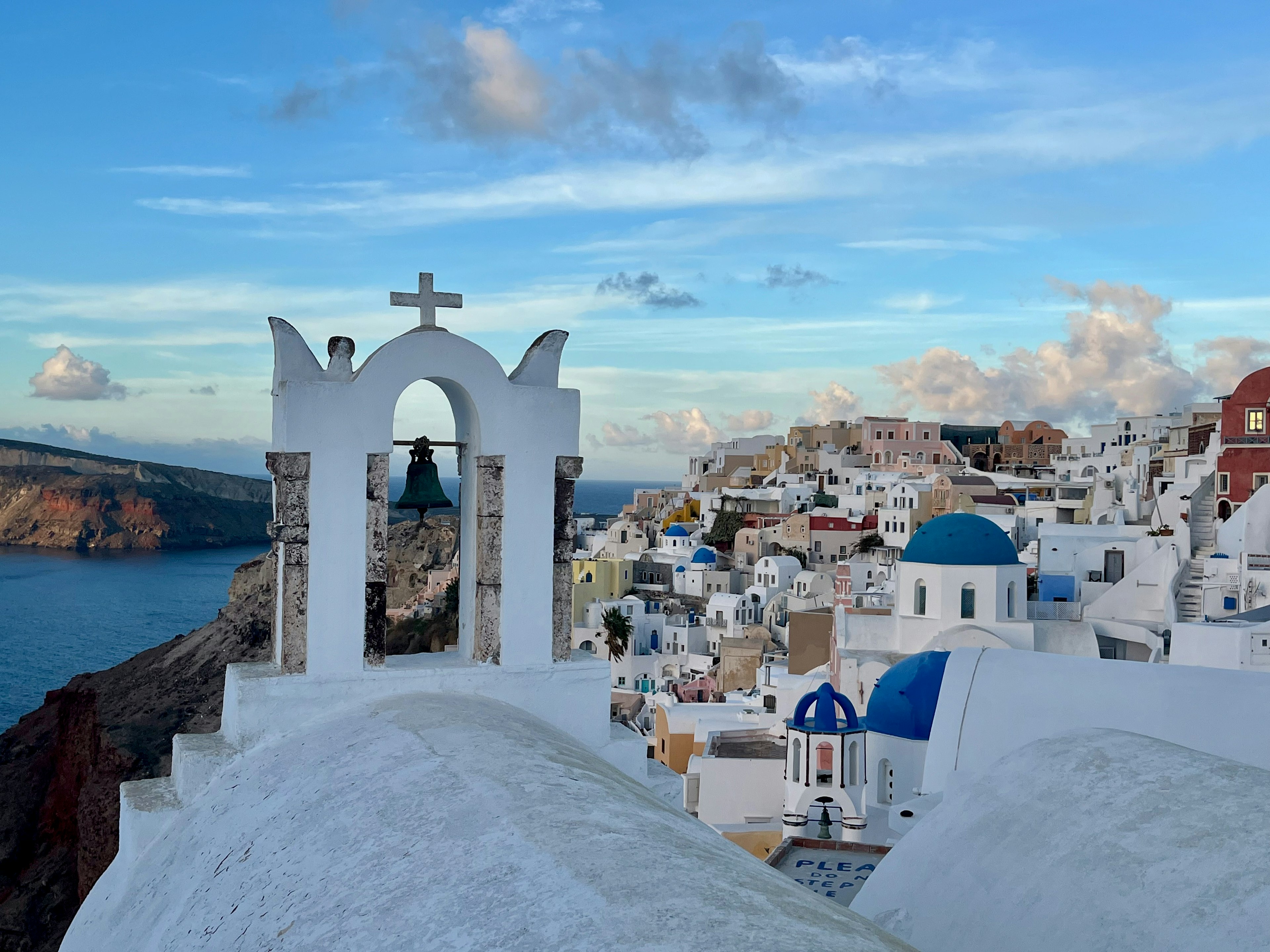 Edificios blancos y cúpulas azules de la isla de Santorini con el mar Egeo de fondo