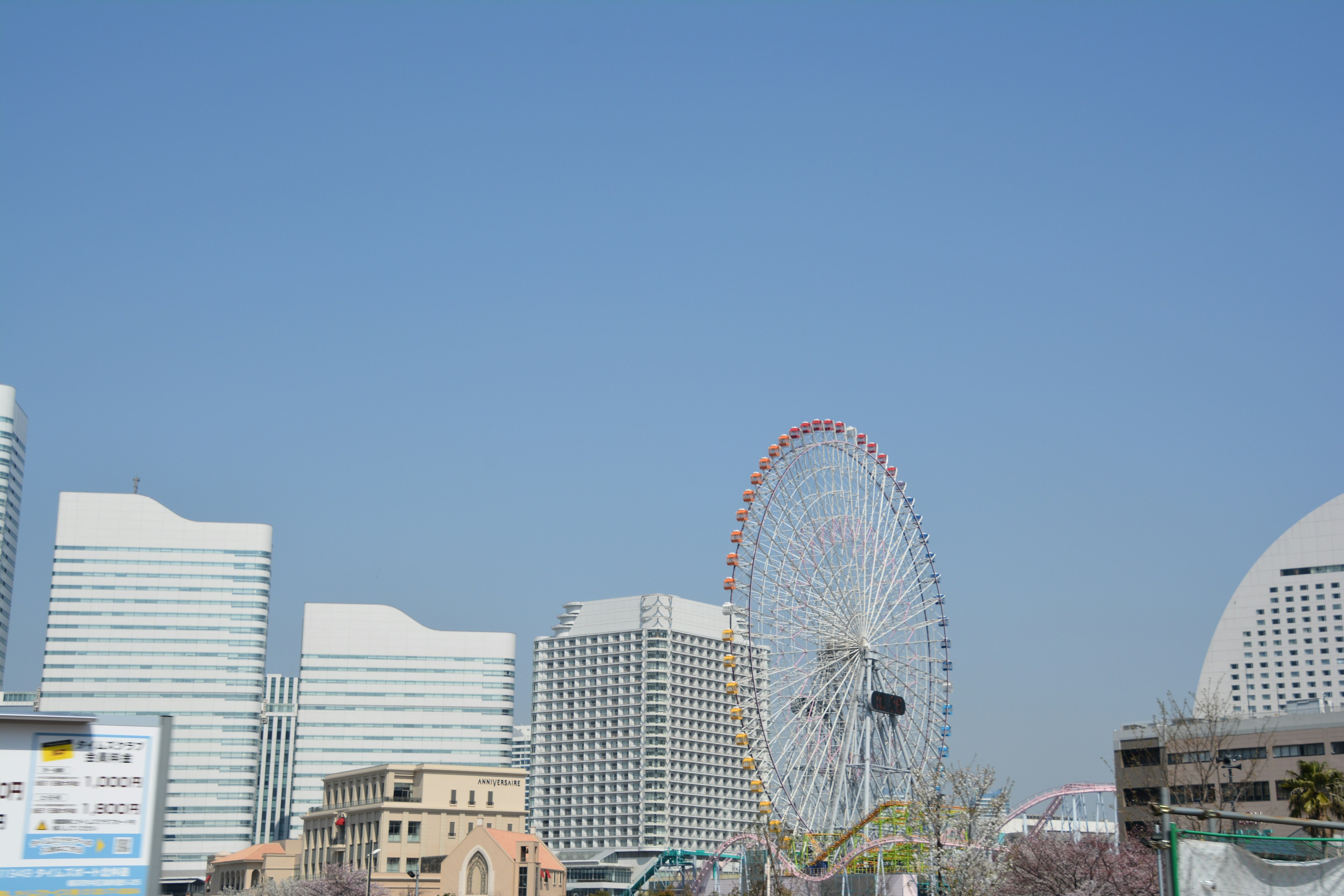 城市景观，蓝天下有高楼和摩天轮