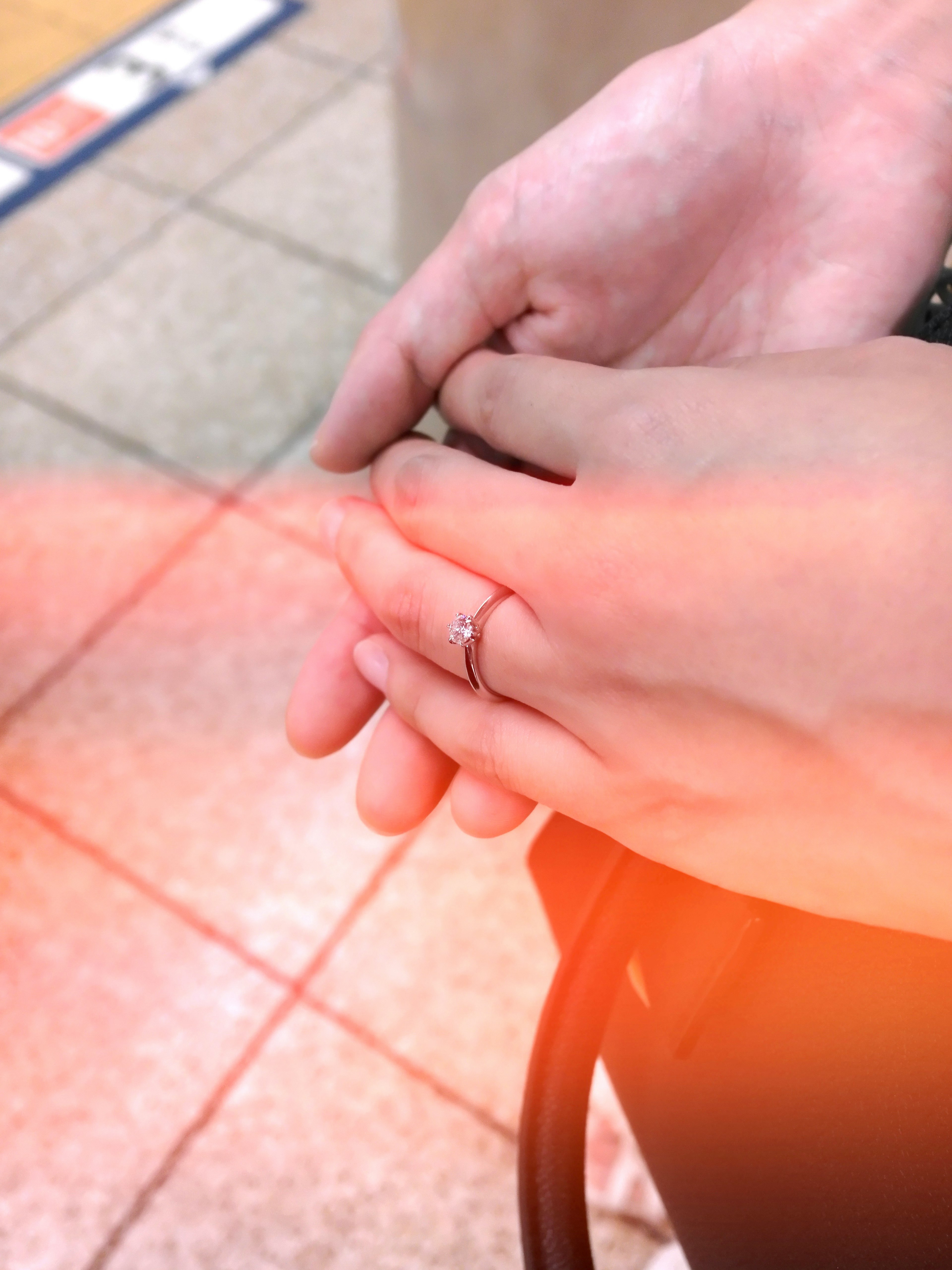 Gros plan de deux mains entrelacées avec une bague sur un doigt