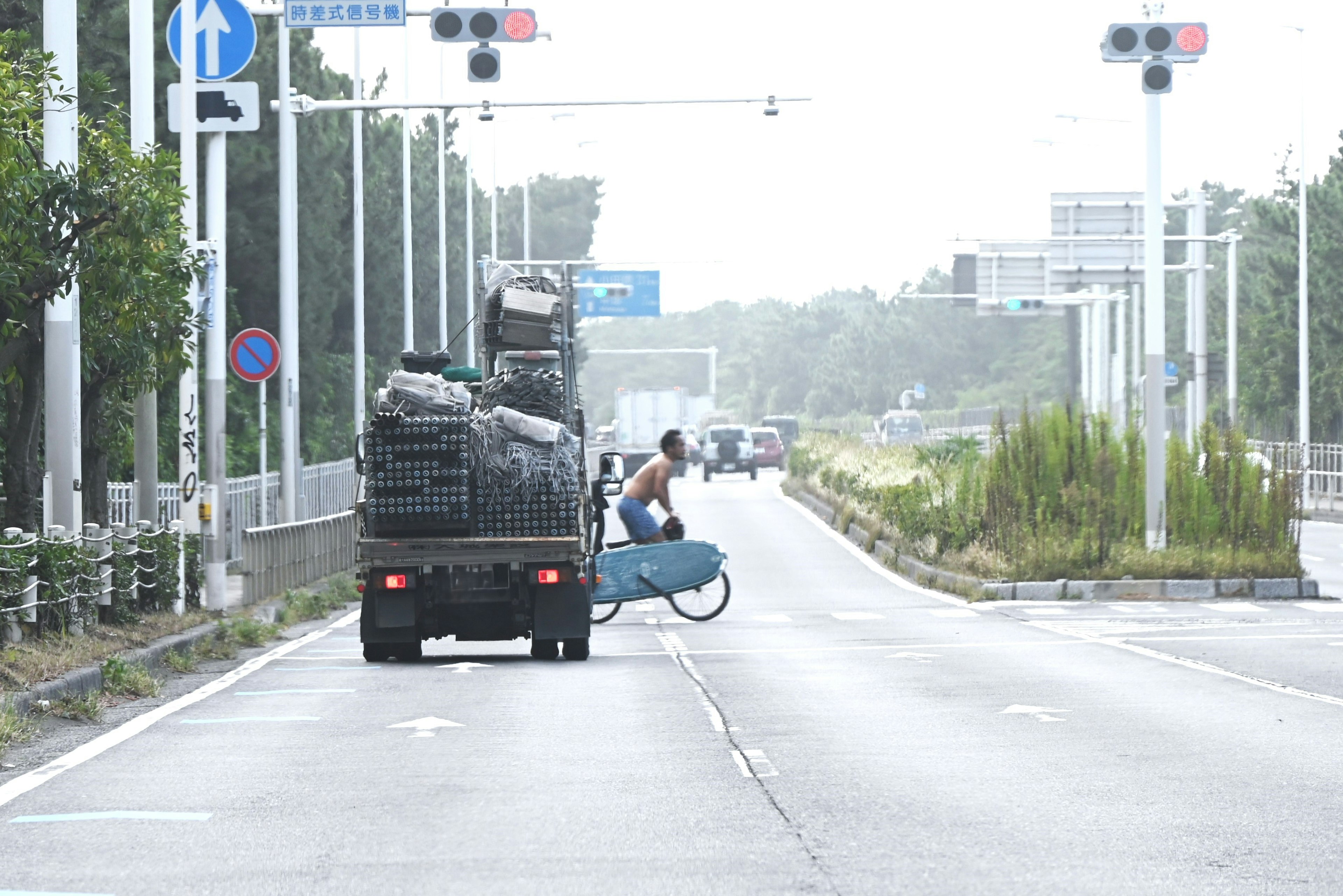 一個人在空曠的道路上運送貨物的卡車後面