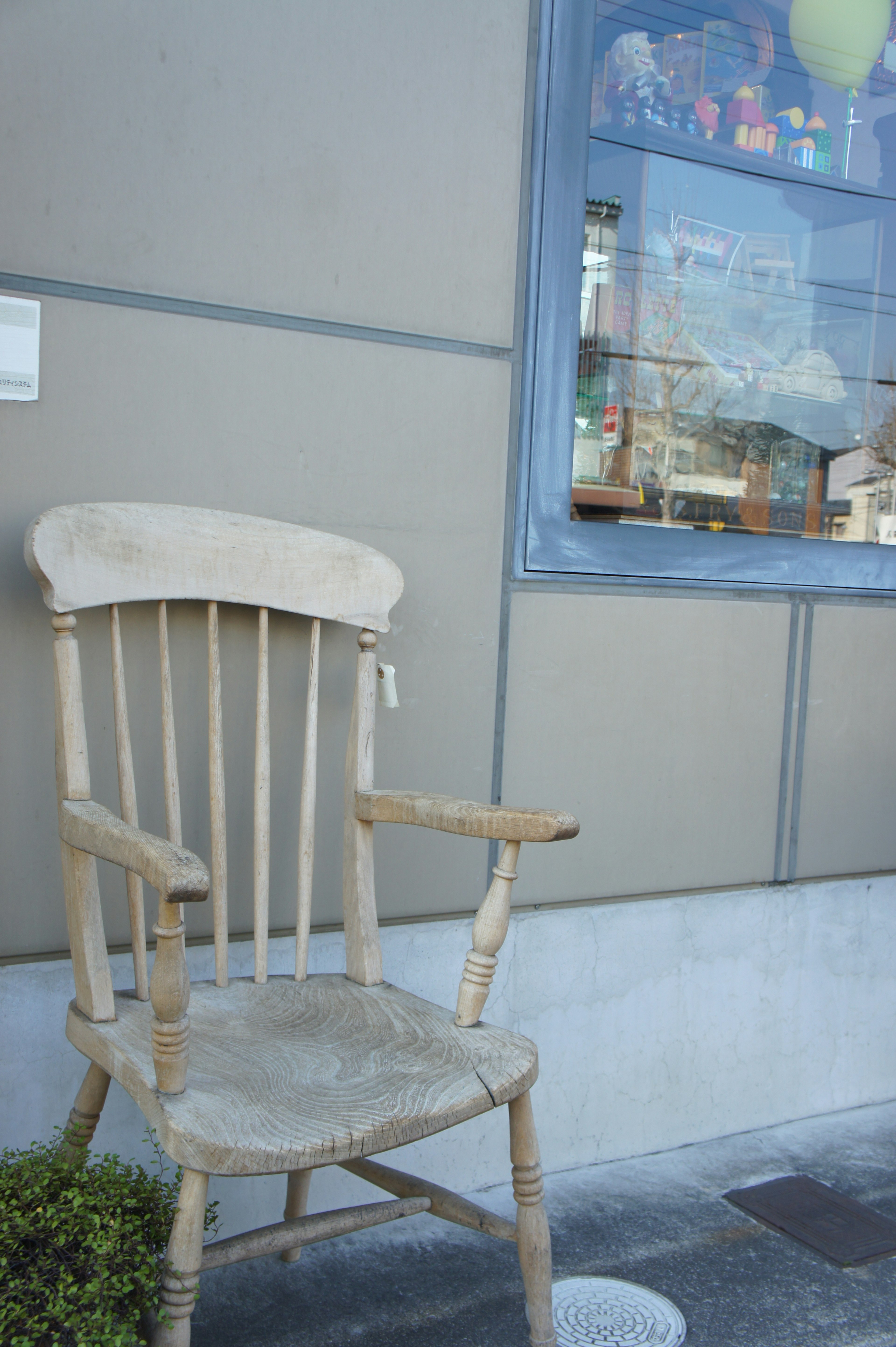 Ein alter Holzstuhl vor einem Schaufenster