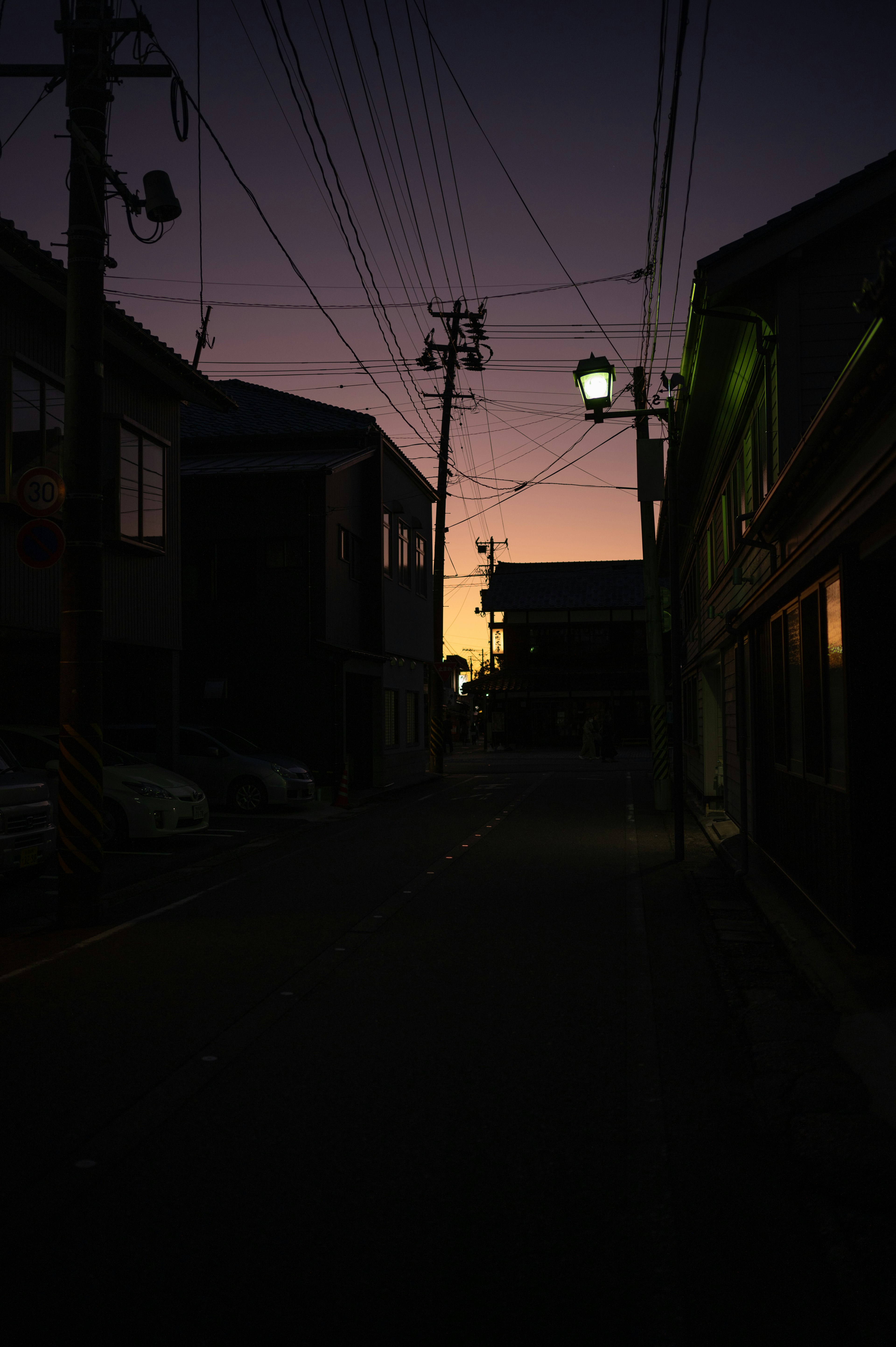 夕暮れ時の静かな街並みと電線のシルエット