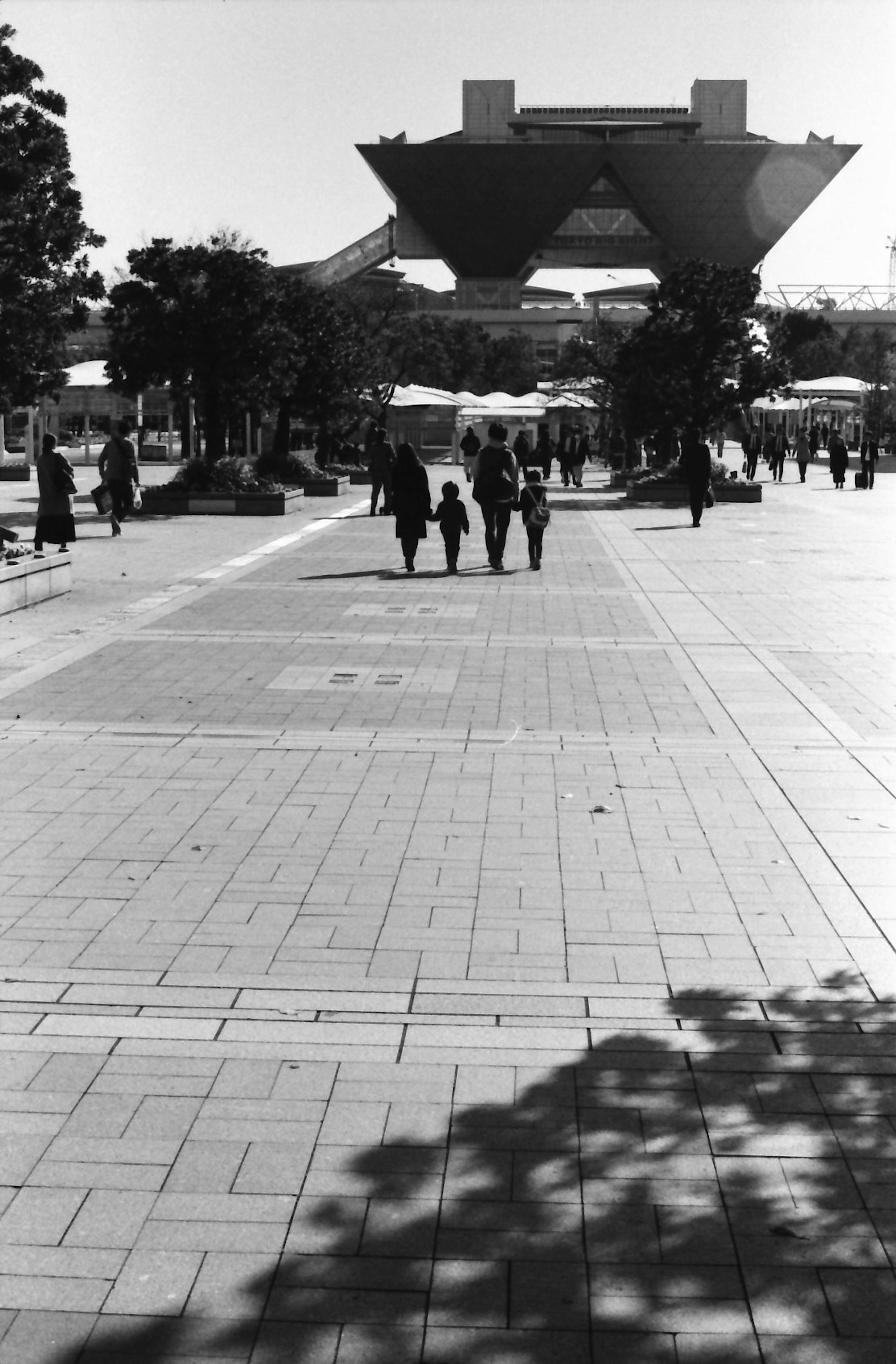 Foto en blanco y negro de personas caminando frente al Tokyo Big Sight