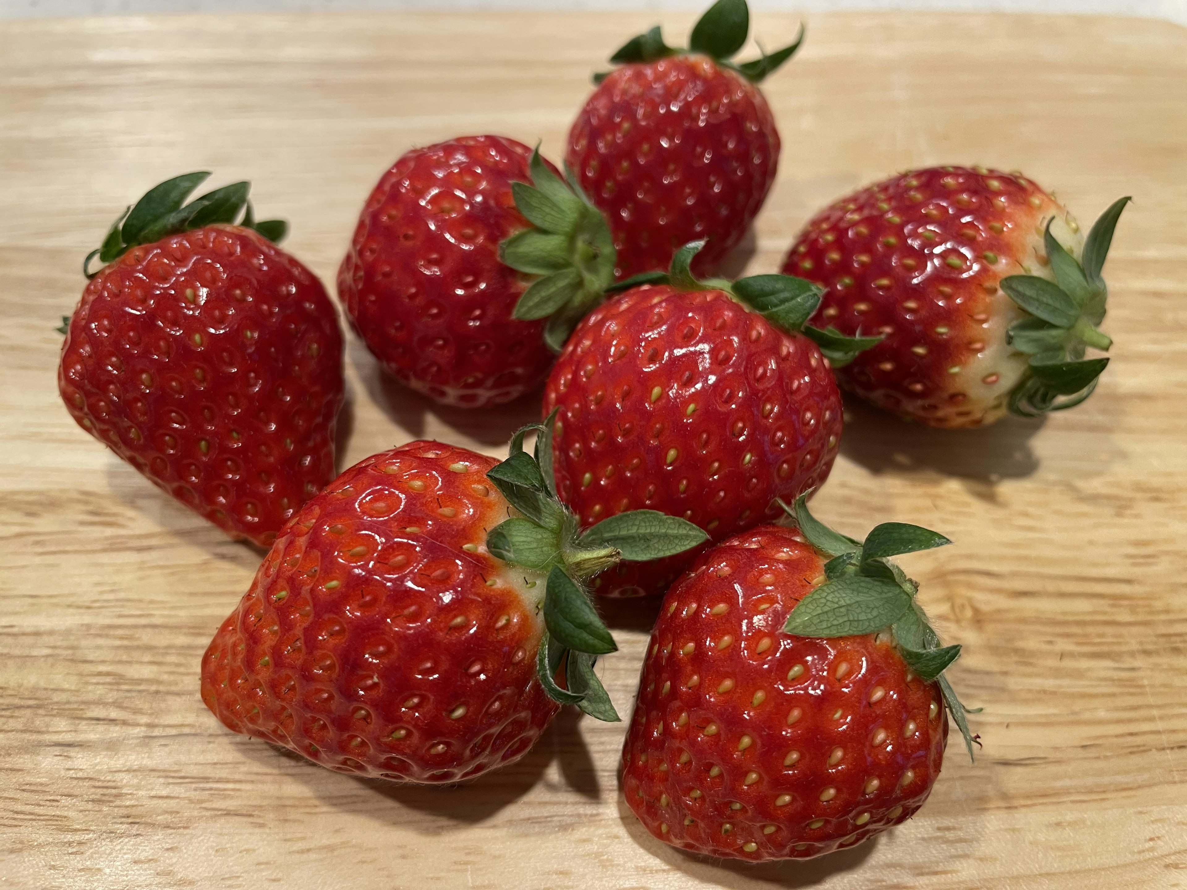 Fresh strawberries arranged on a wooden table