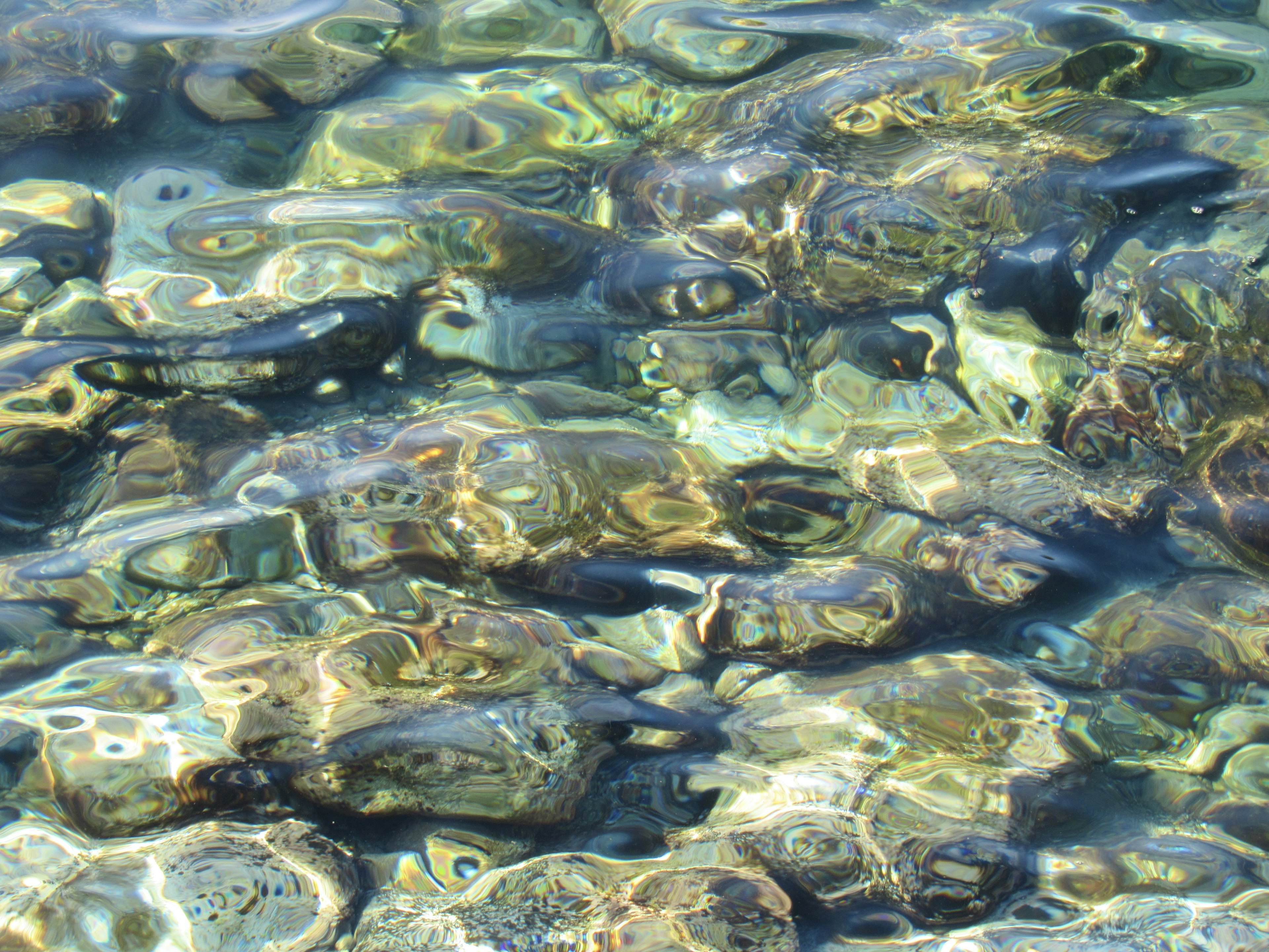 Bild von klarem Meerwasser, das Steine unter der Oberfläche zeigt