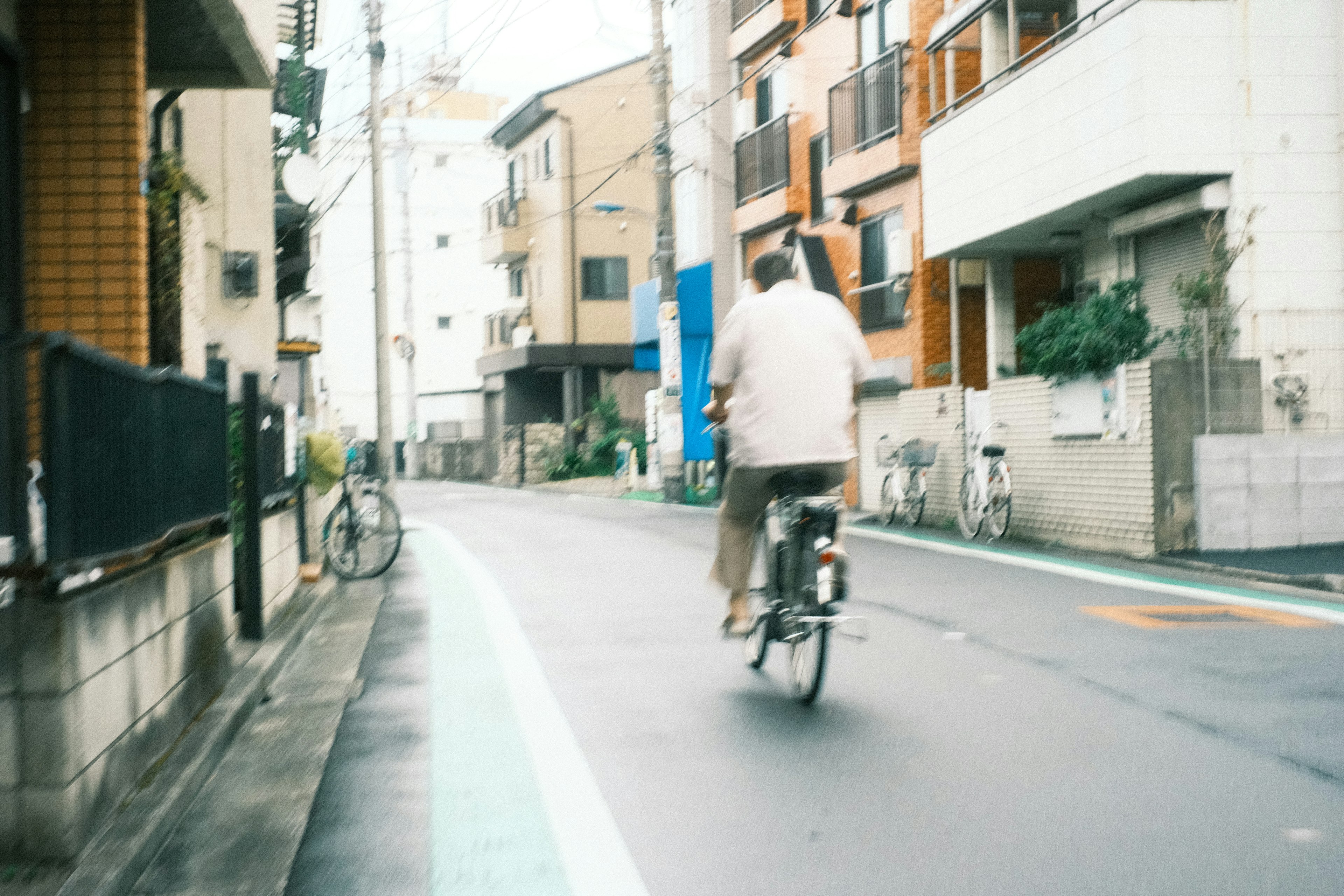 自転車に乗っている男性が狭い街路を通り過ぎている風景