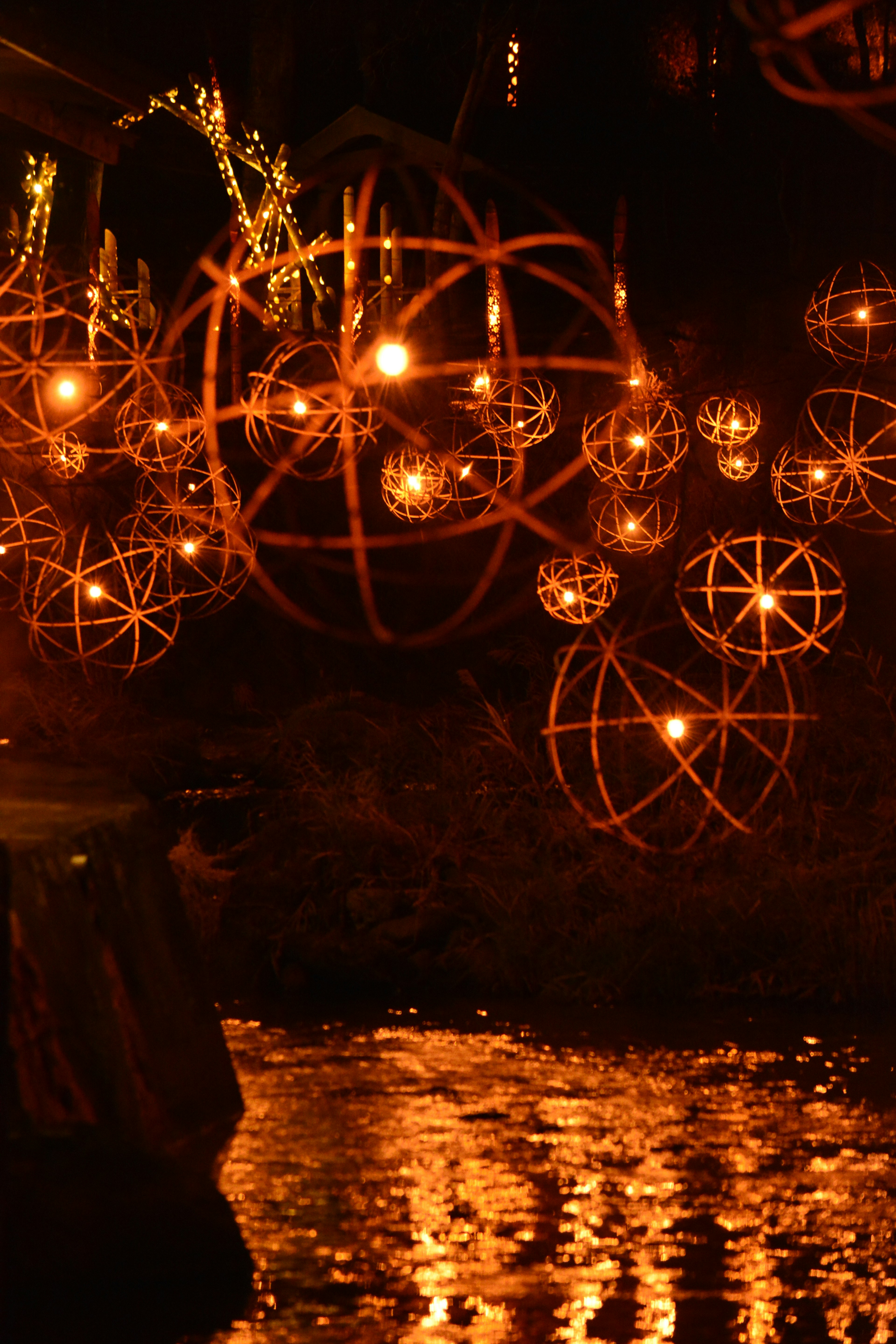 Cluster of glowing orbs above a reflective water surface with warm colors