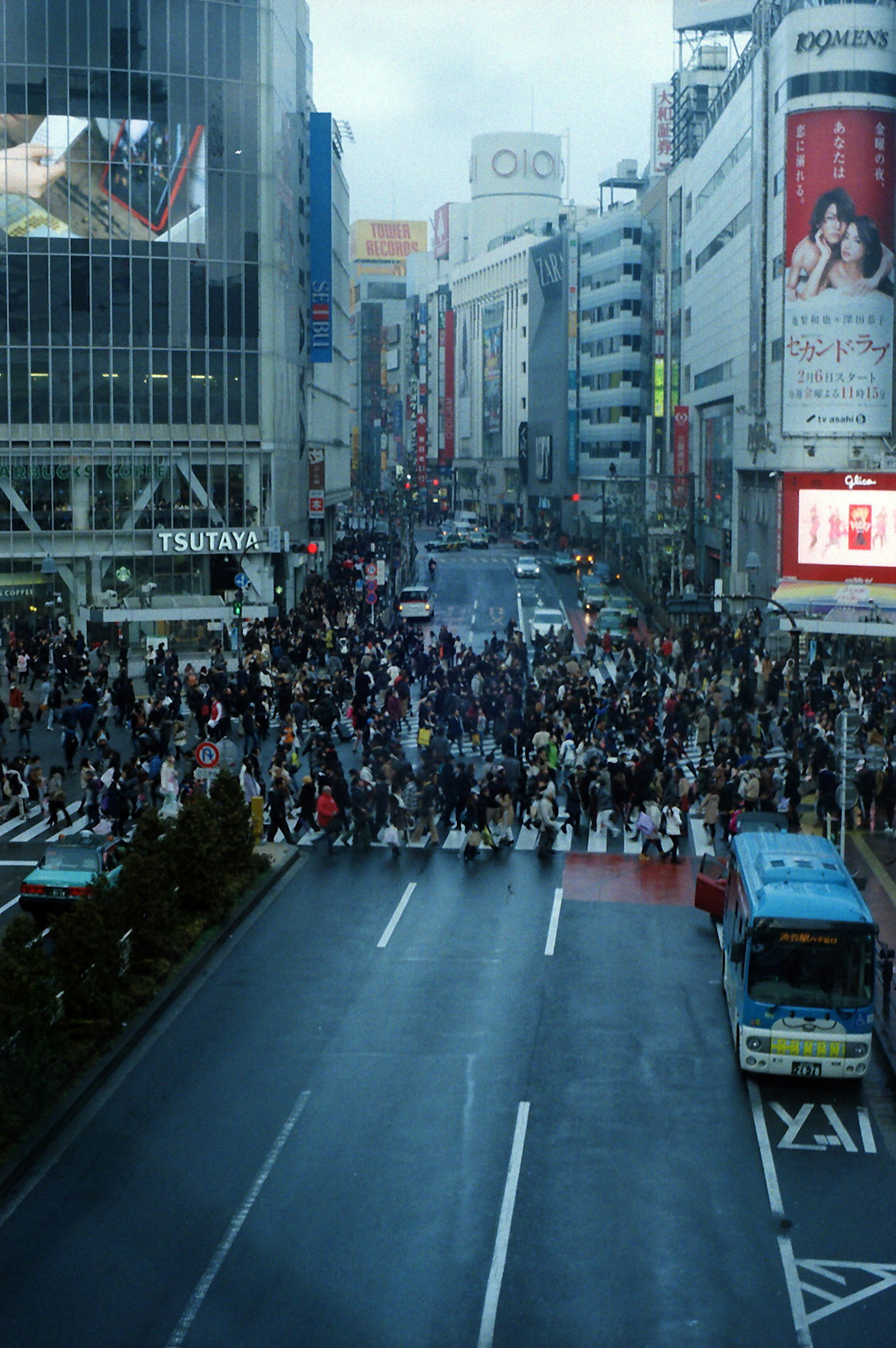 Crowd gathering at Shibuya Crossing with city buildings in the background