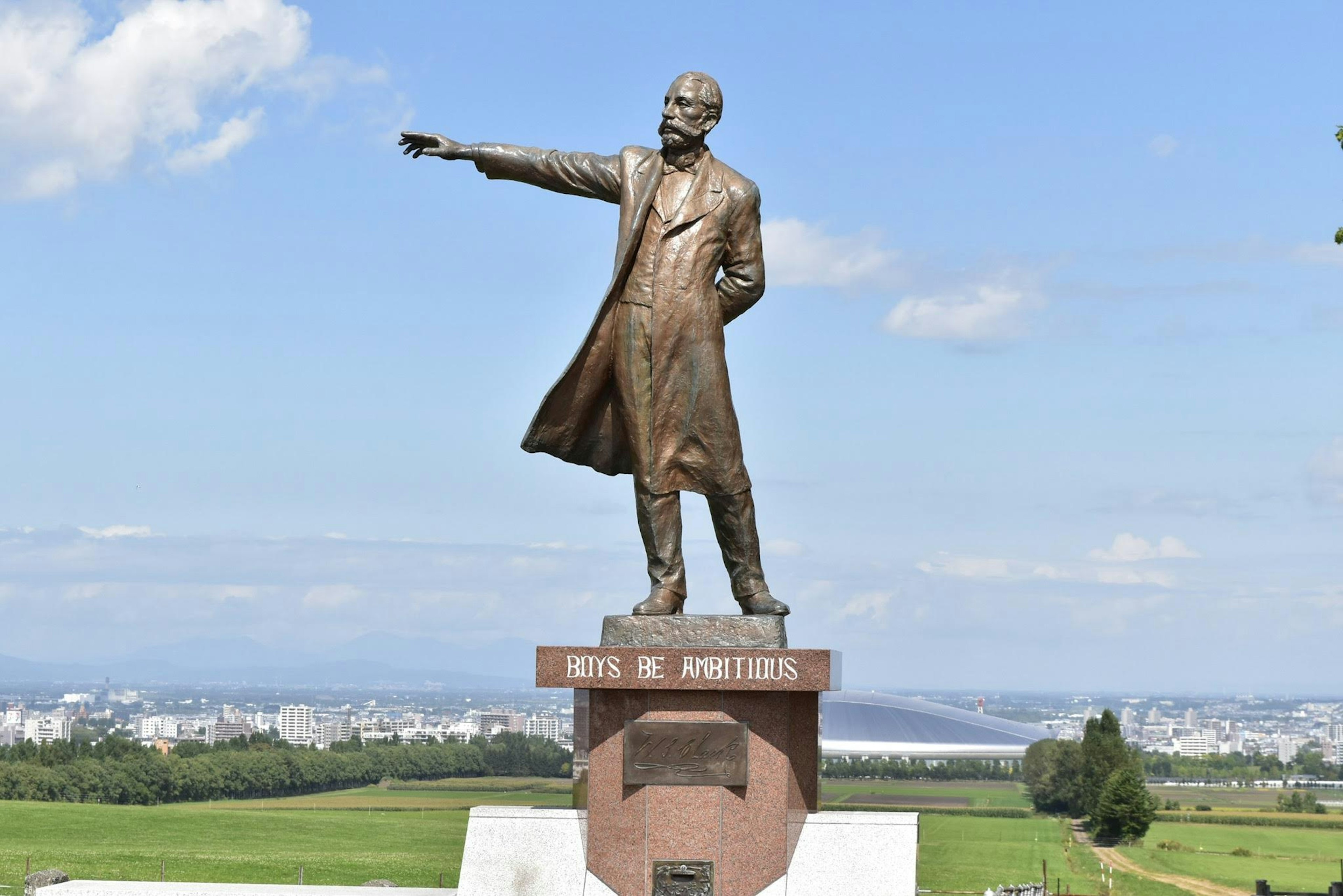 Bronze statue of Lenin standing under a blue sky pointing into the distance