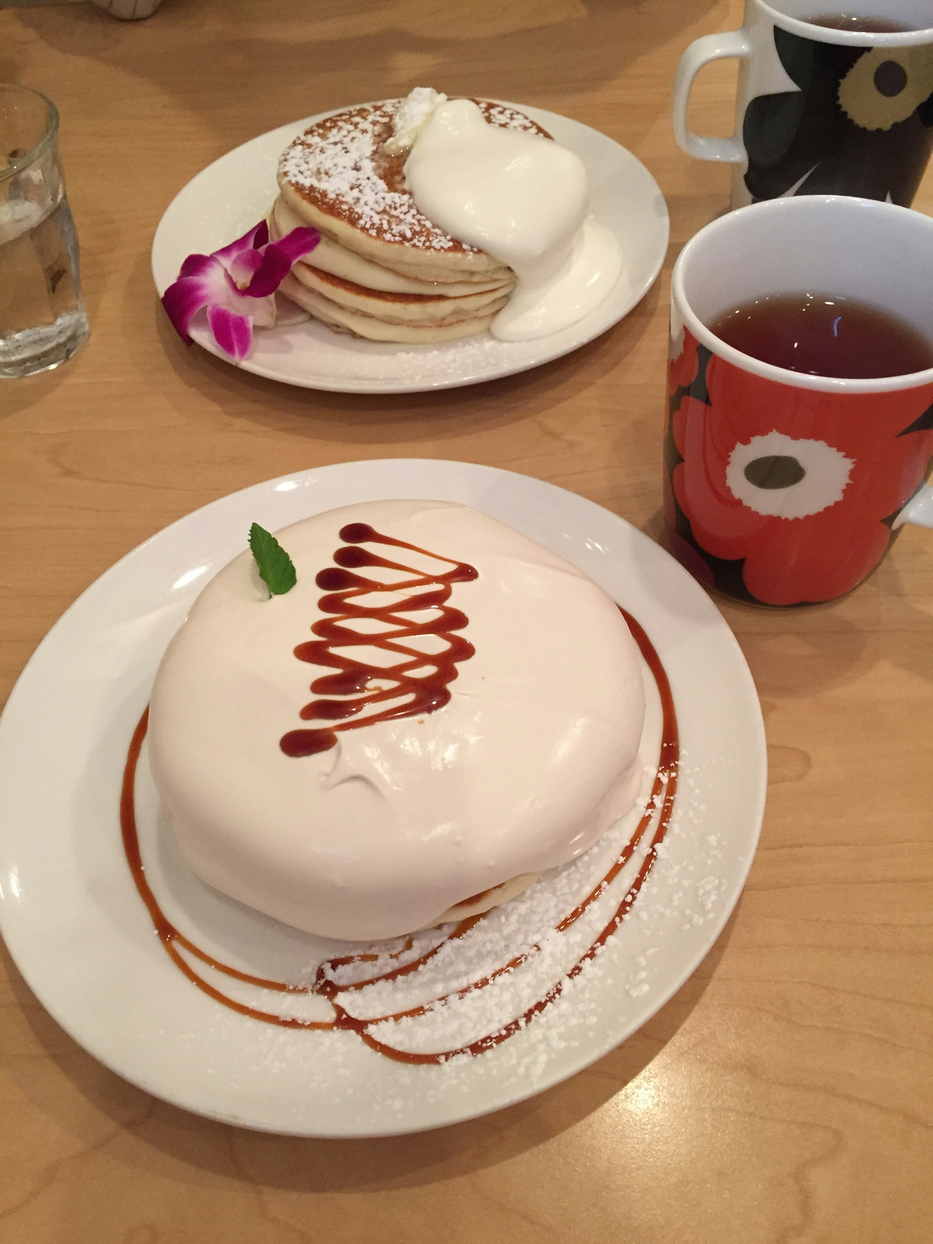 Creamy dessert with a drizzle and pancakes on a table