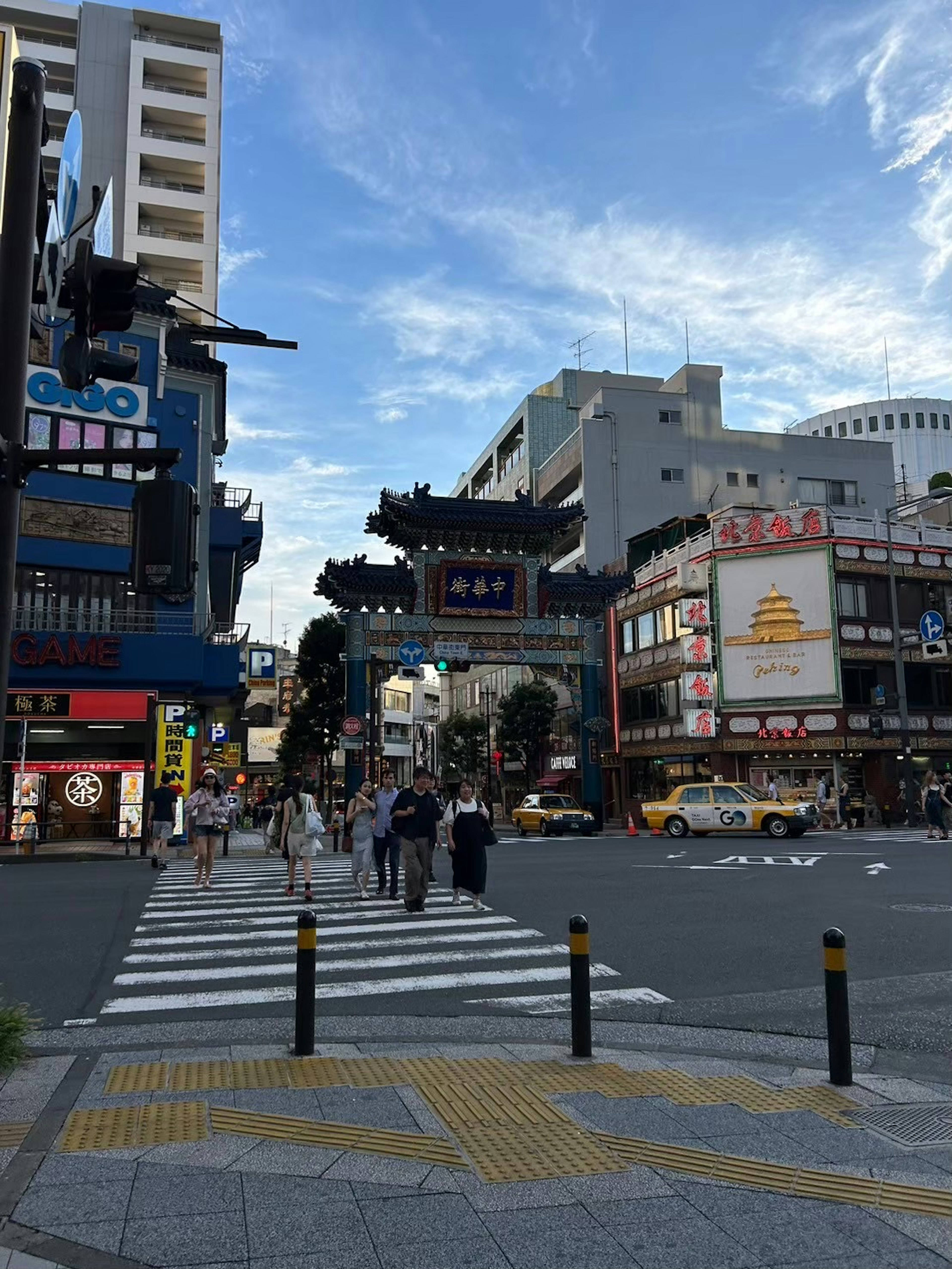 繁華街の横断歩道に立つ人々と高層ビルの背景