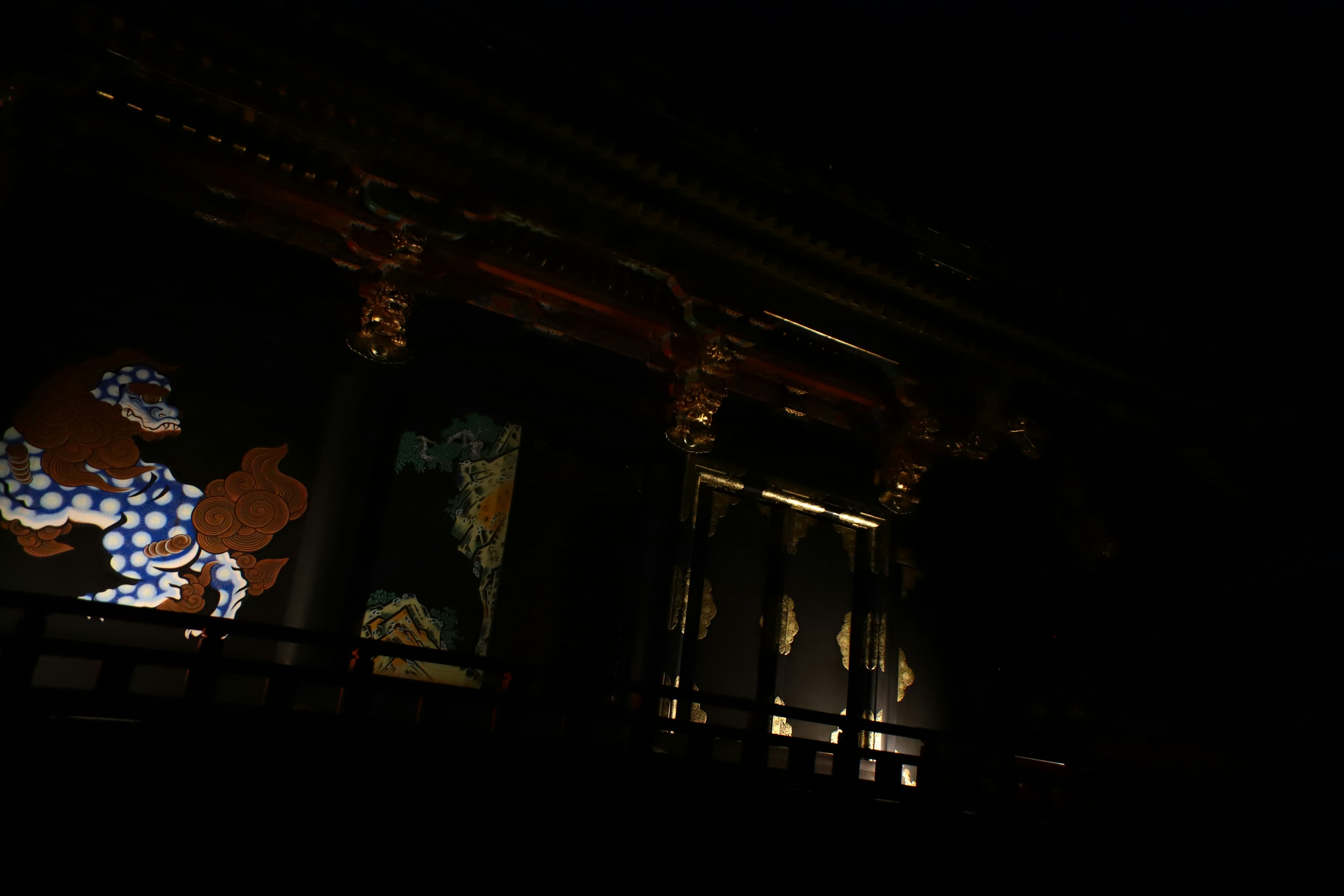 Traditional Japanese wall paintings and decorative architecture illuminated in darkness