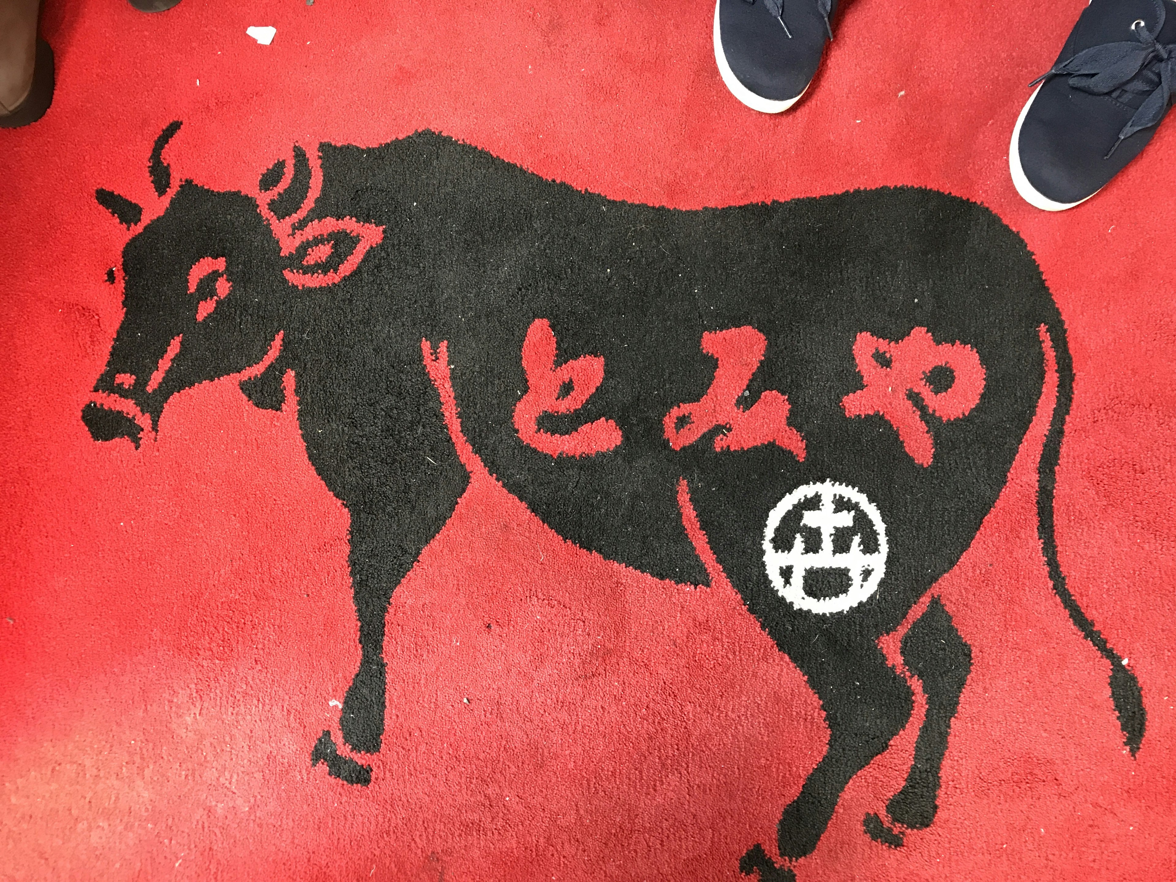 Black cow design on red carpet with red characters