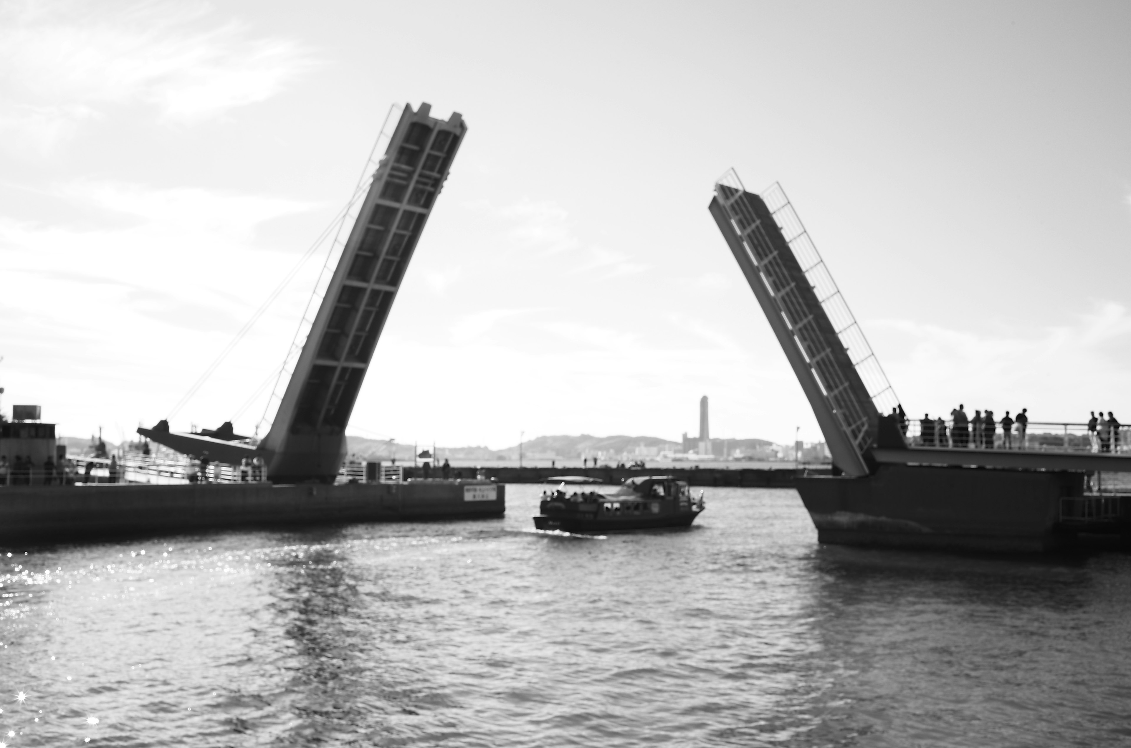 Dua jembatan angkat yang terangkat dengan perahu yang lewat di bawahnya