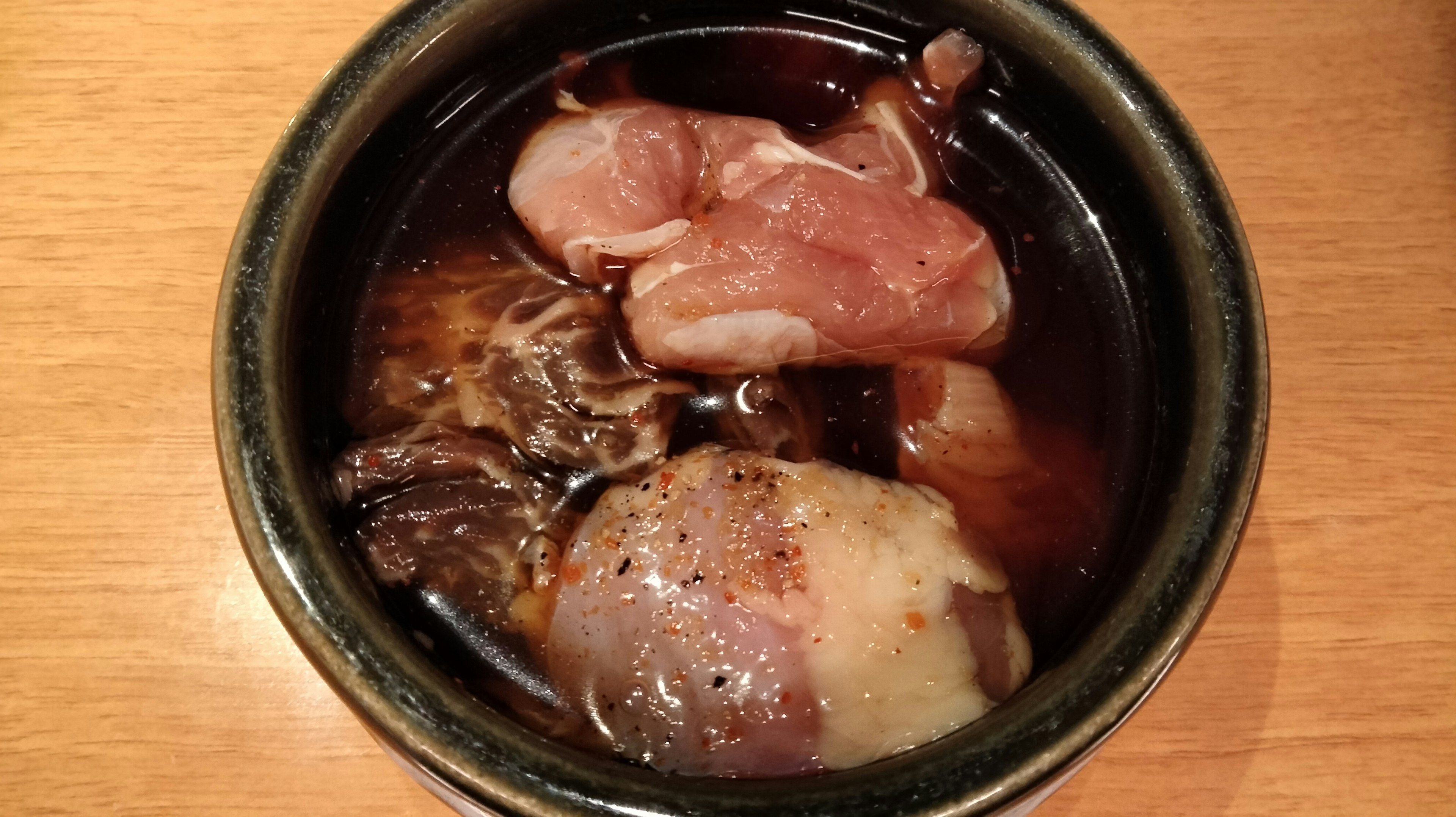 A close-up of a traditional stew featuring various meats and vegetables