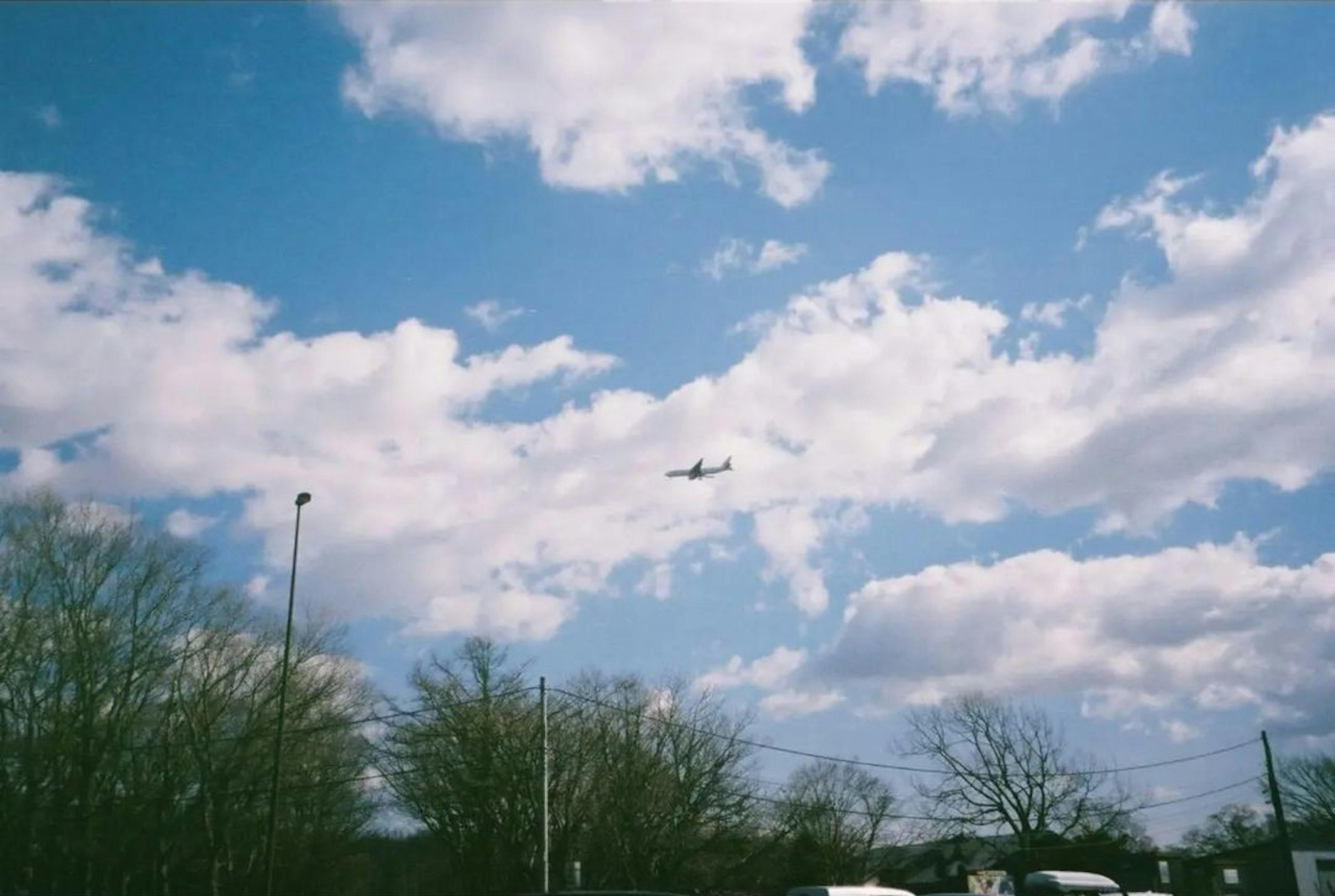 青空に浮かぶ飛行機と白い雲の風景