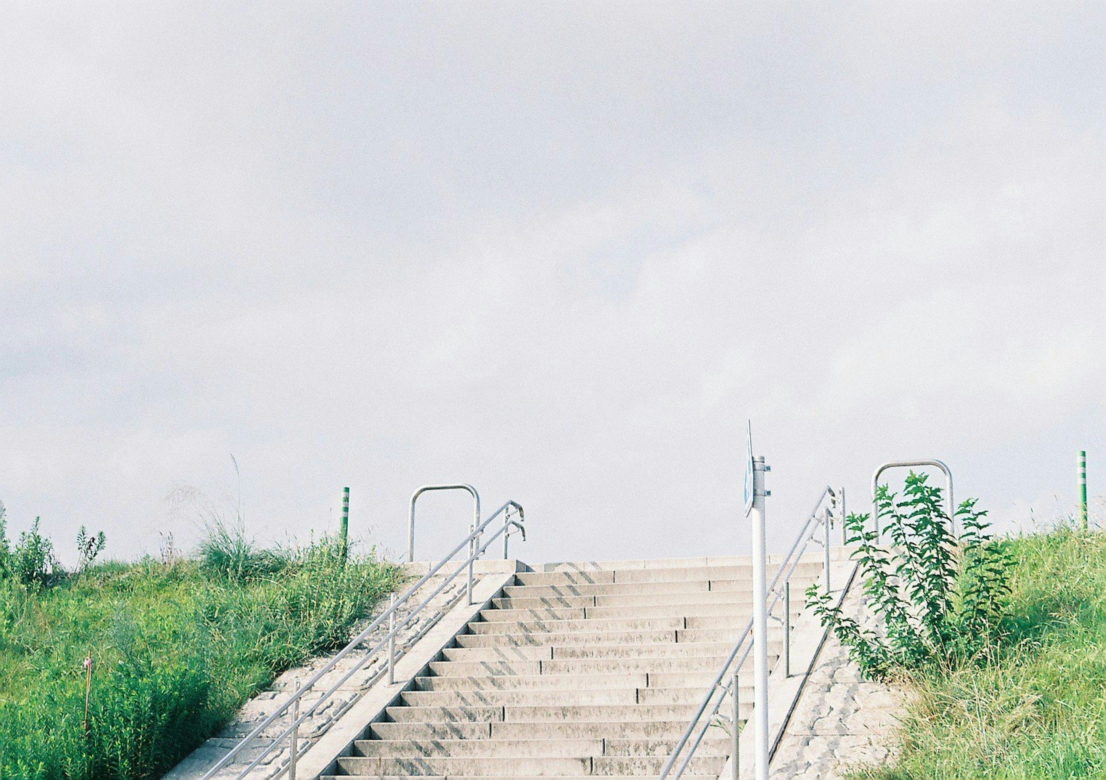 Treppe umgeben von grünem Gras unter einem hellen Himmel