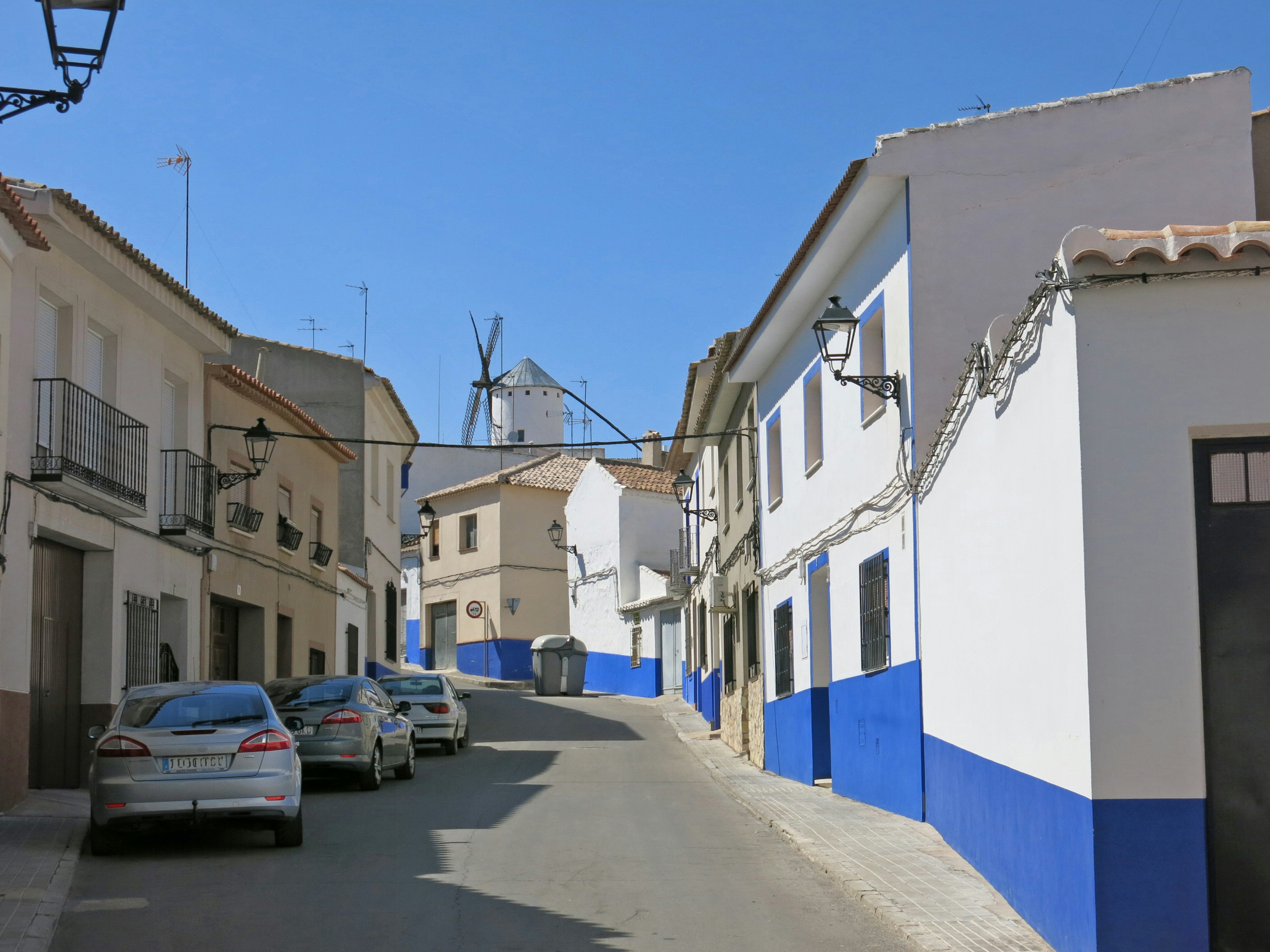 Strada stretta con case bianche e muri blu