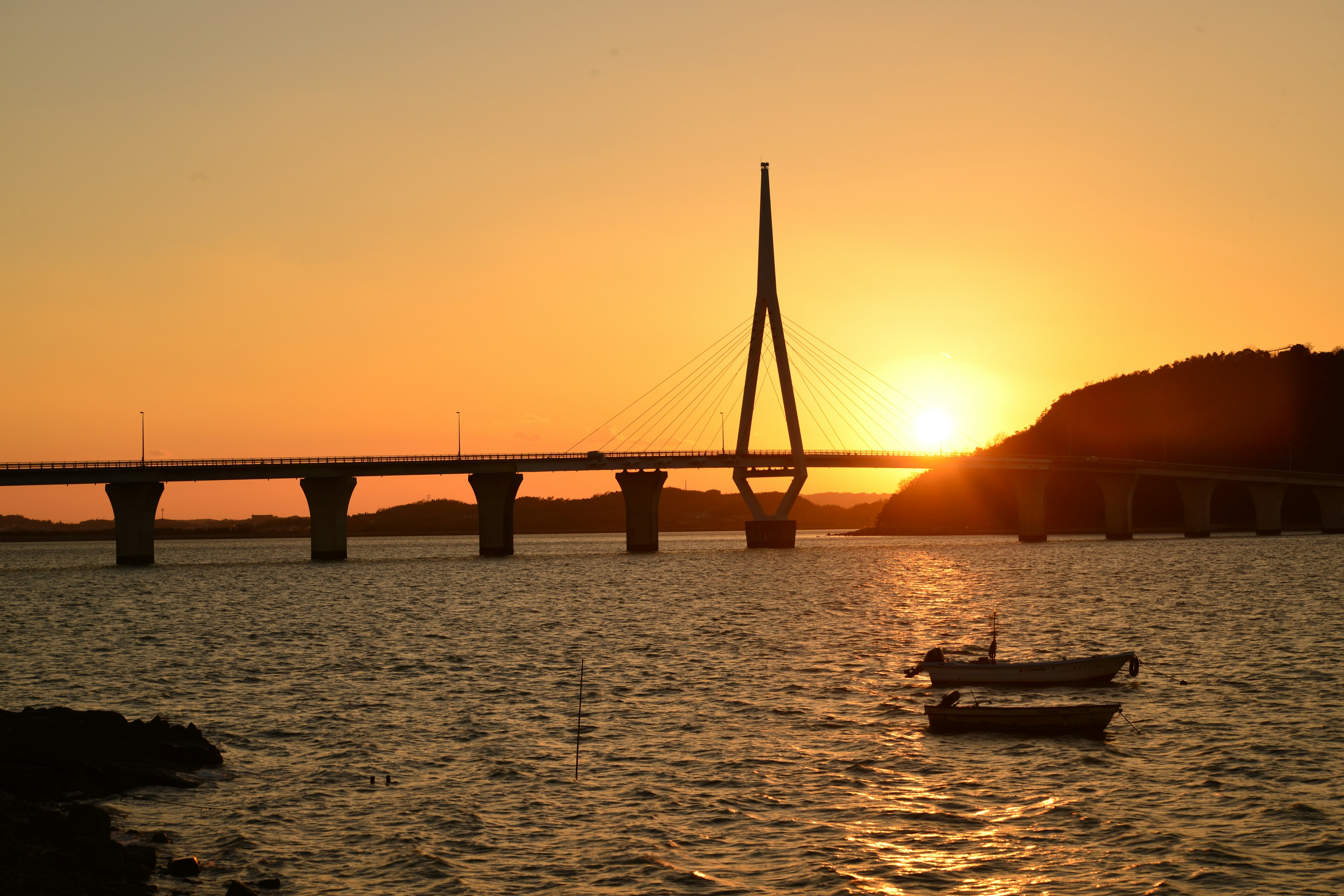 Bellissimo ponte che attraversa il fiume al tramonto con una piccola barca