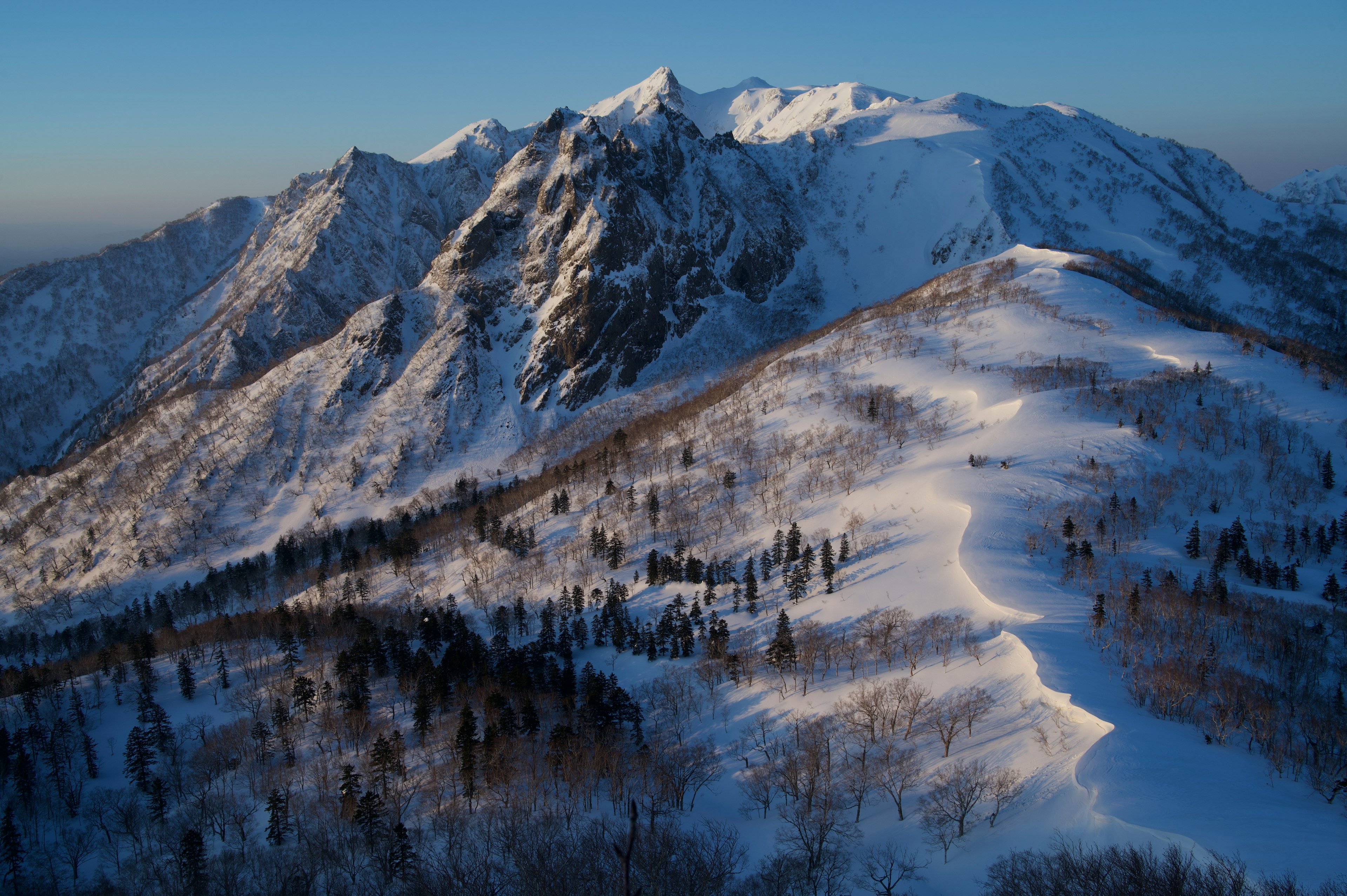 雪に覆われた山々の壮大な景色と青い空