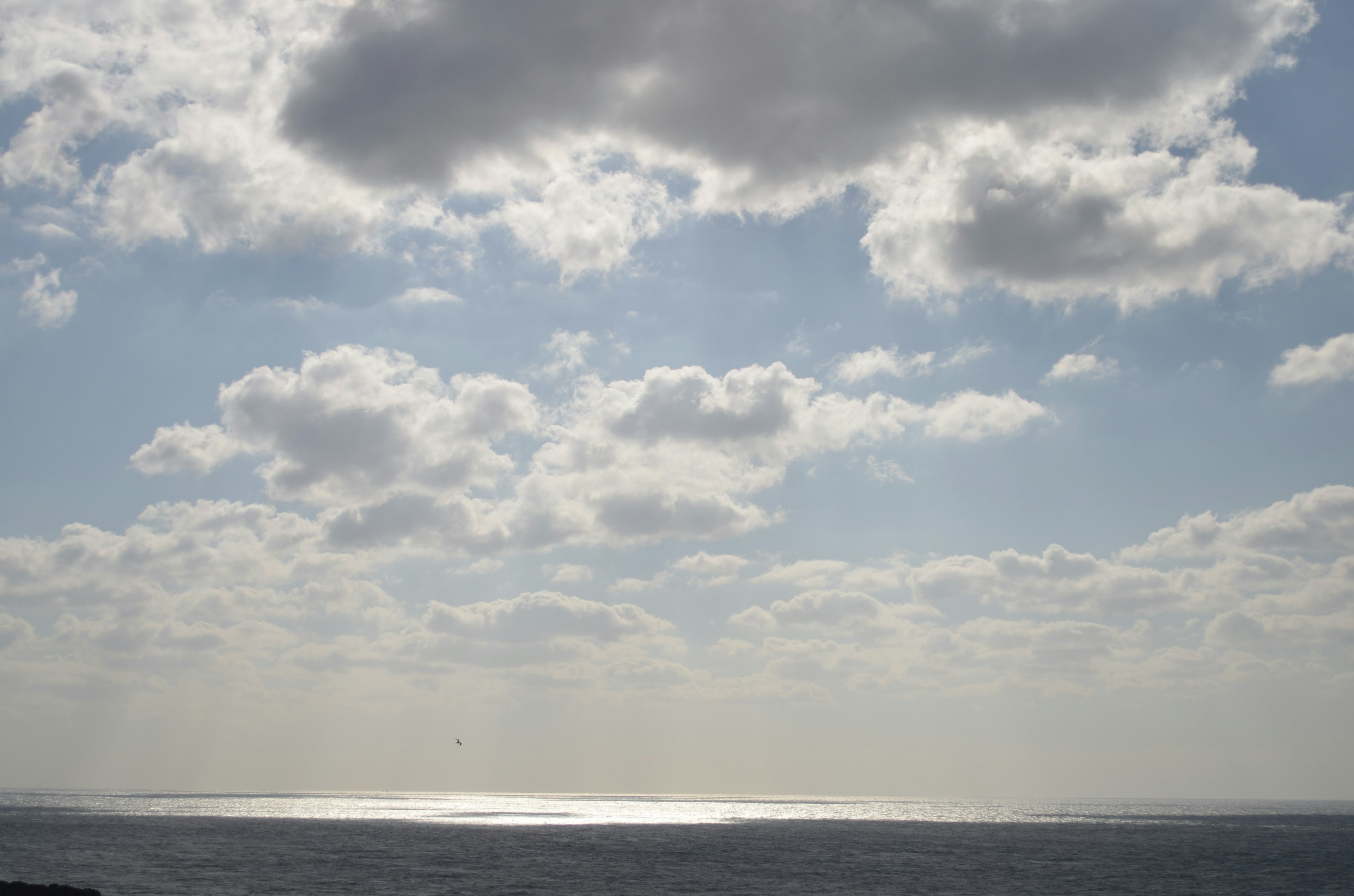 Landschaft mit blauem Meer und weißen Wolken im Himmel