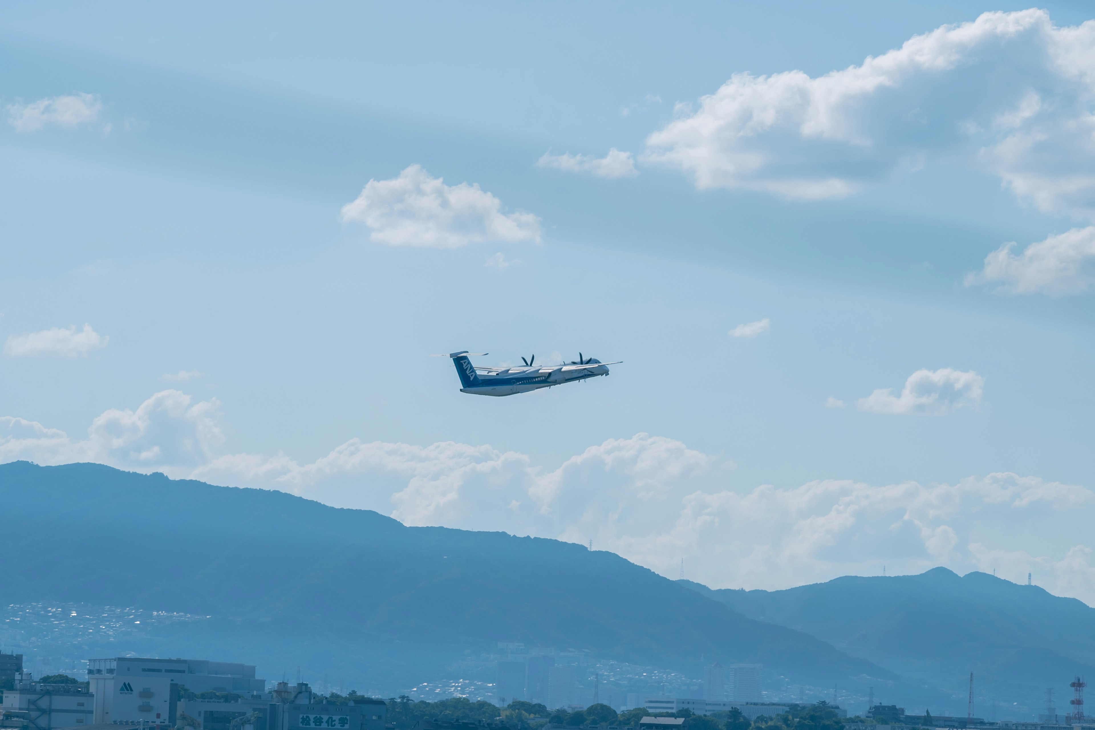 Avion décollant contre un ciel bleu et des montagnes