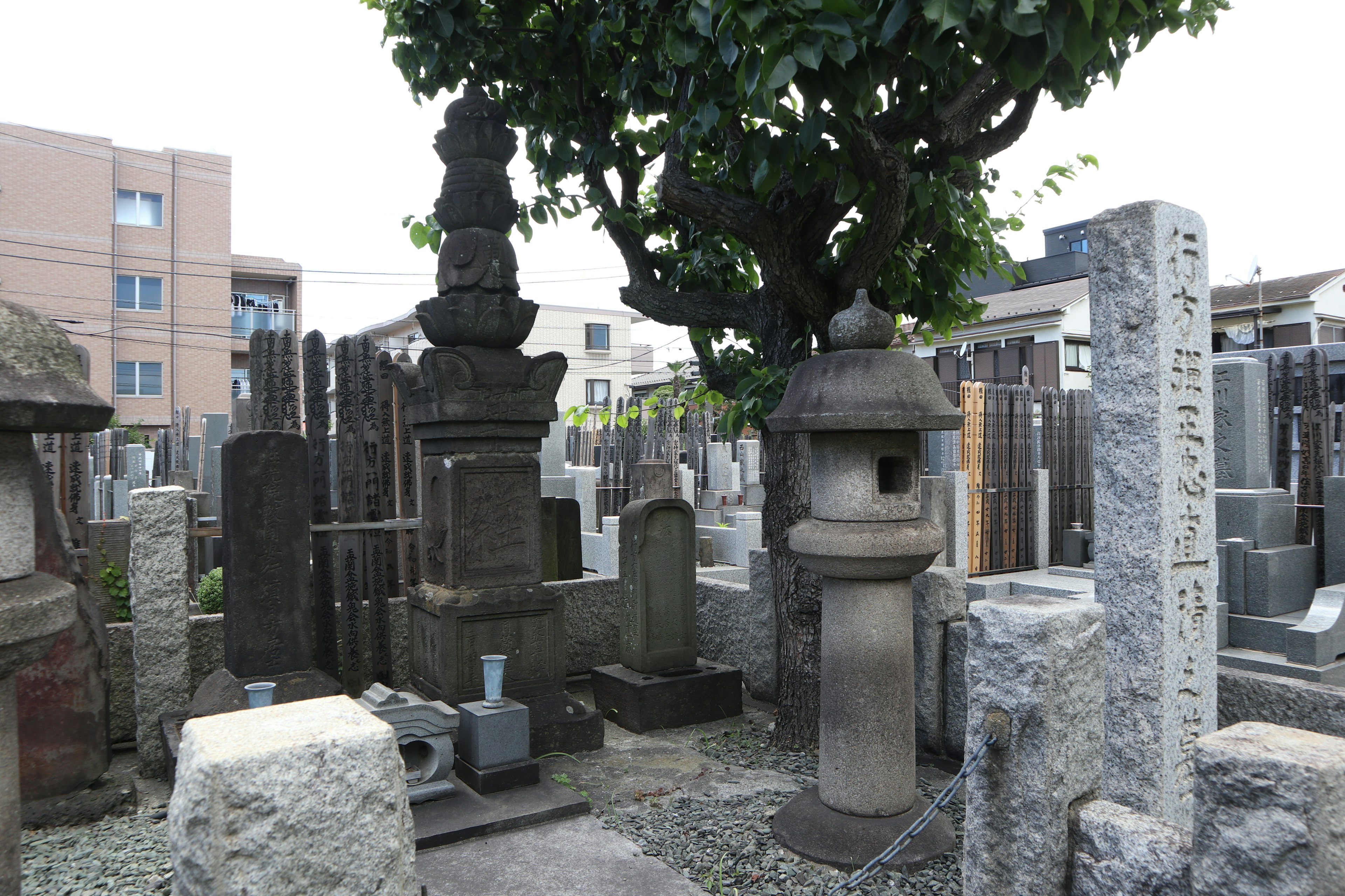 Graveyard scene featuring stone tombstones lanterns and a tree