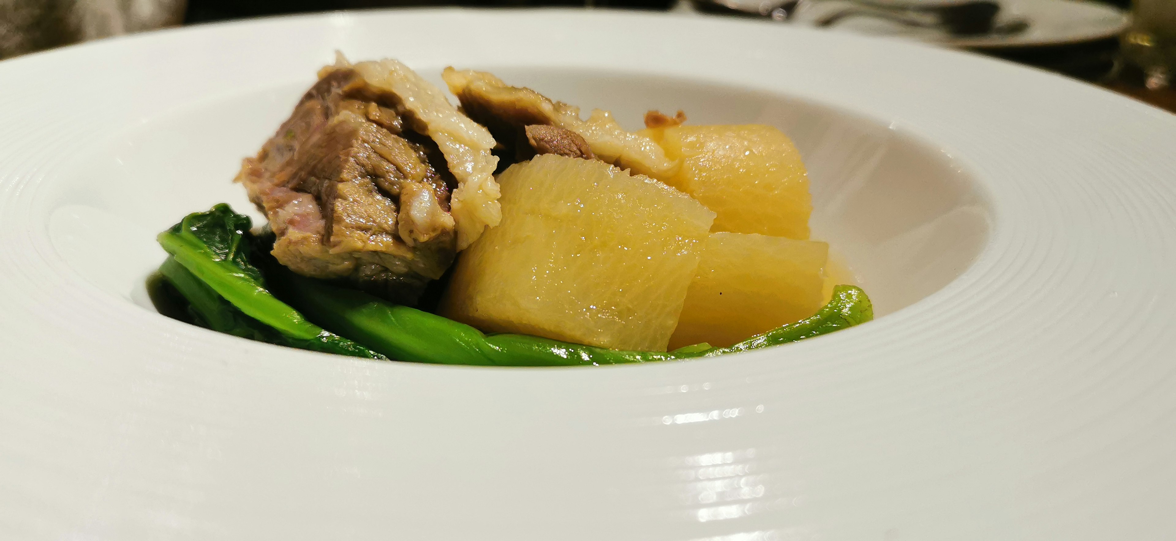 Plat de viande et légumes servi dans une assiette blanche