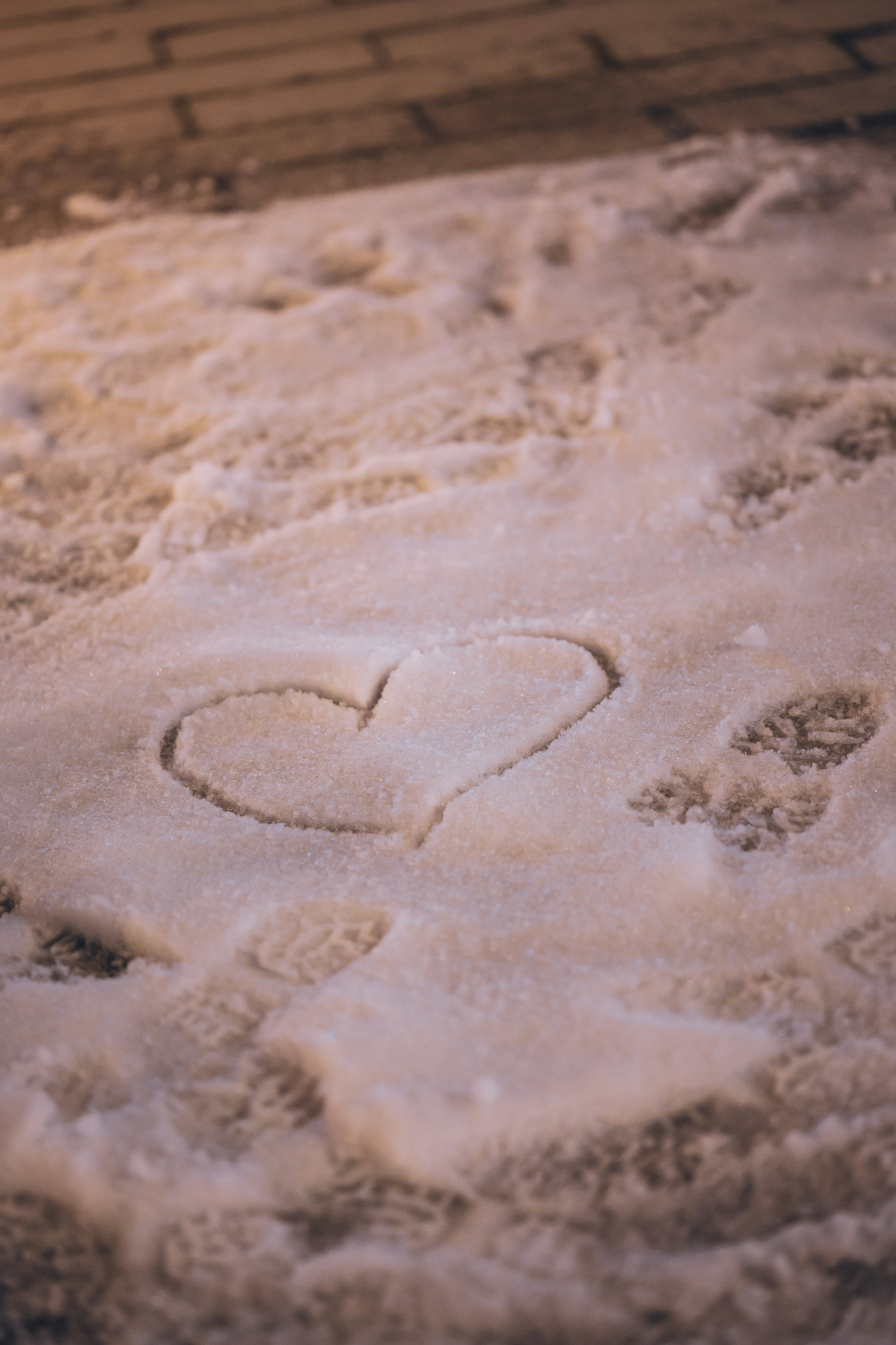 Corazón dibujado en la nieve con huellas