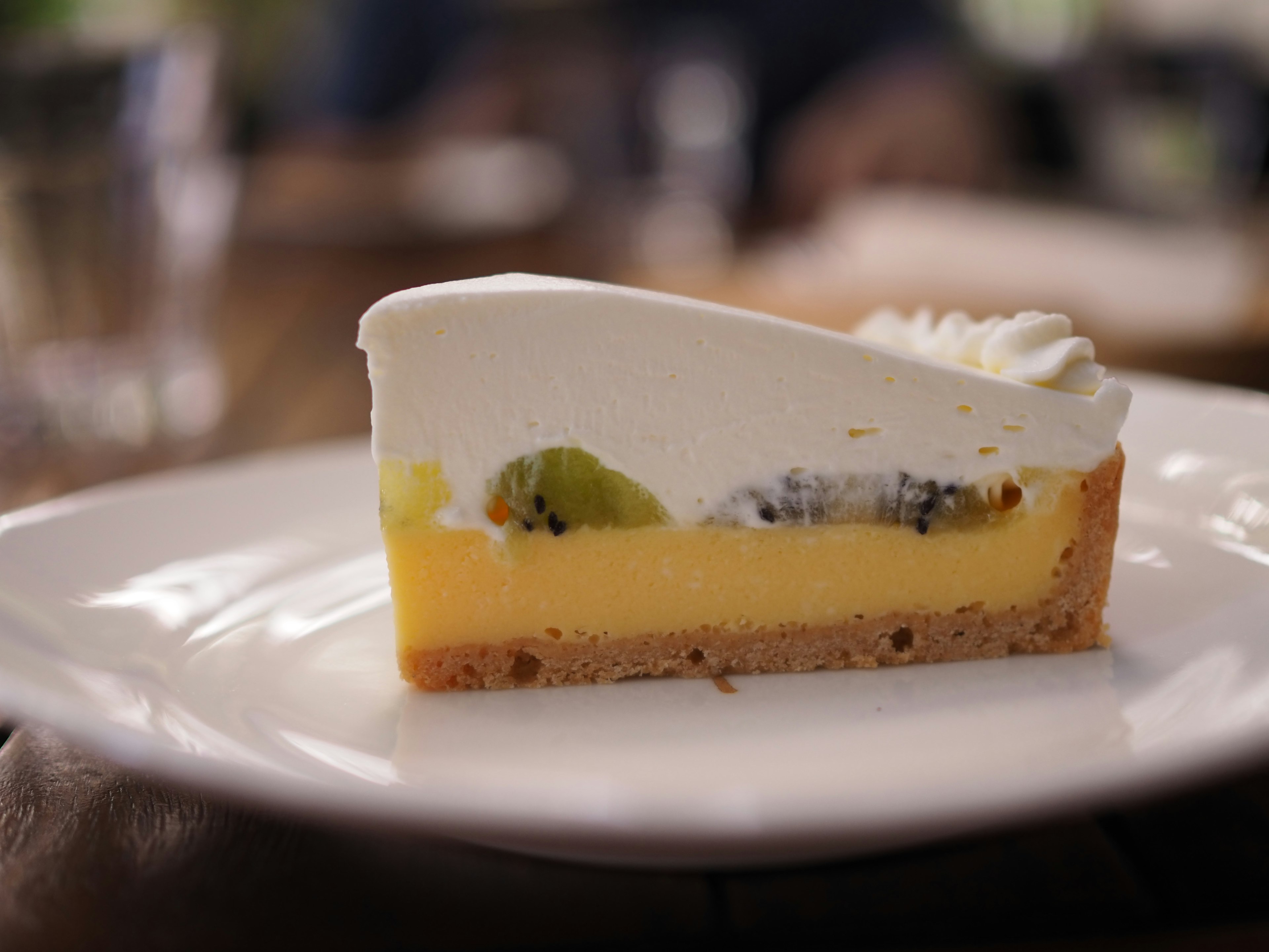 Cross-section of a cake topped with cream and fruits