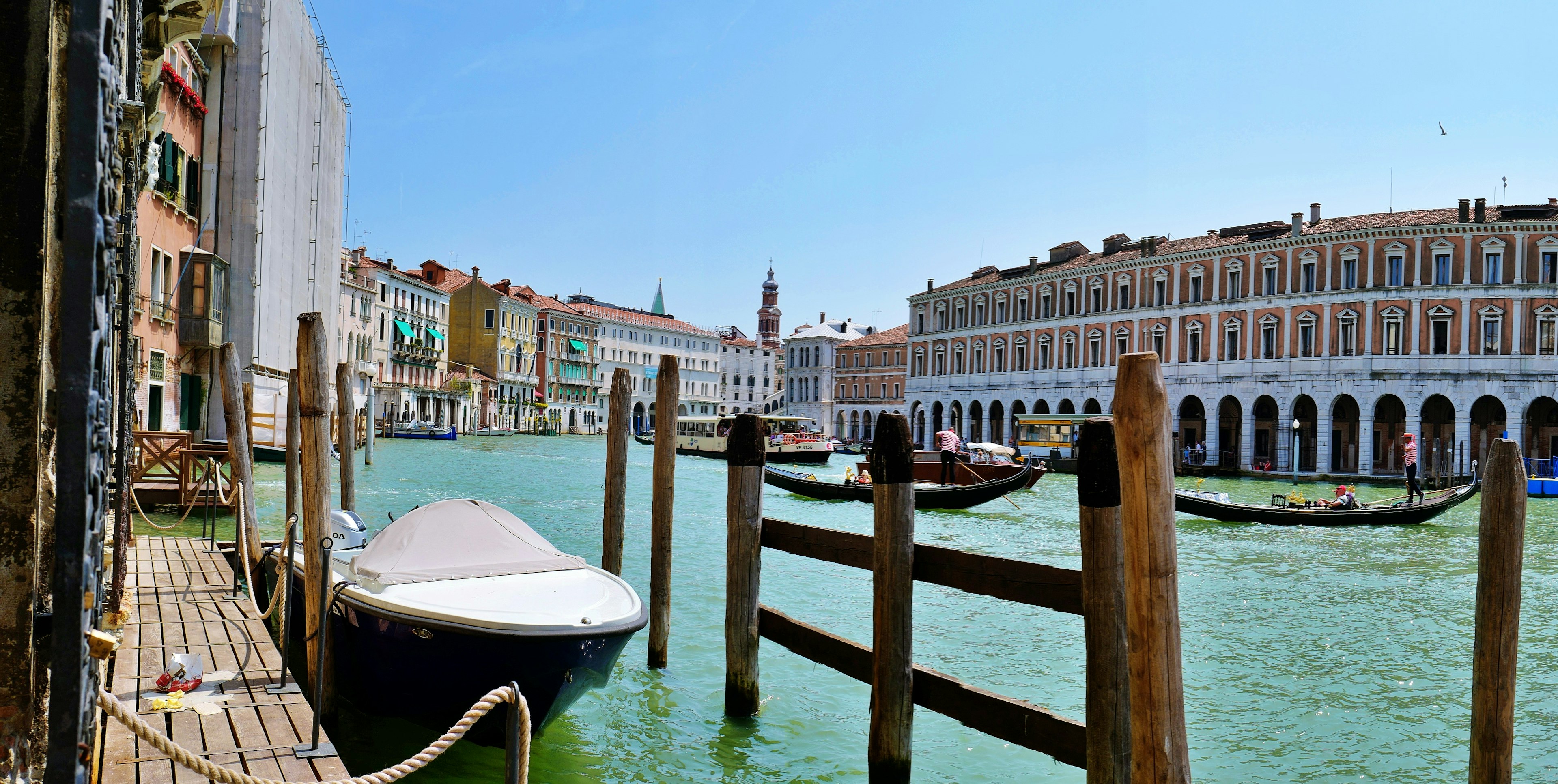 Vue magnifique des canaux de Venise avec des bateaux et des quais en bois