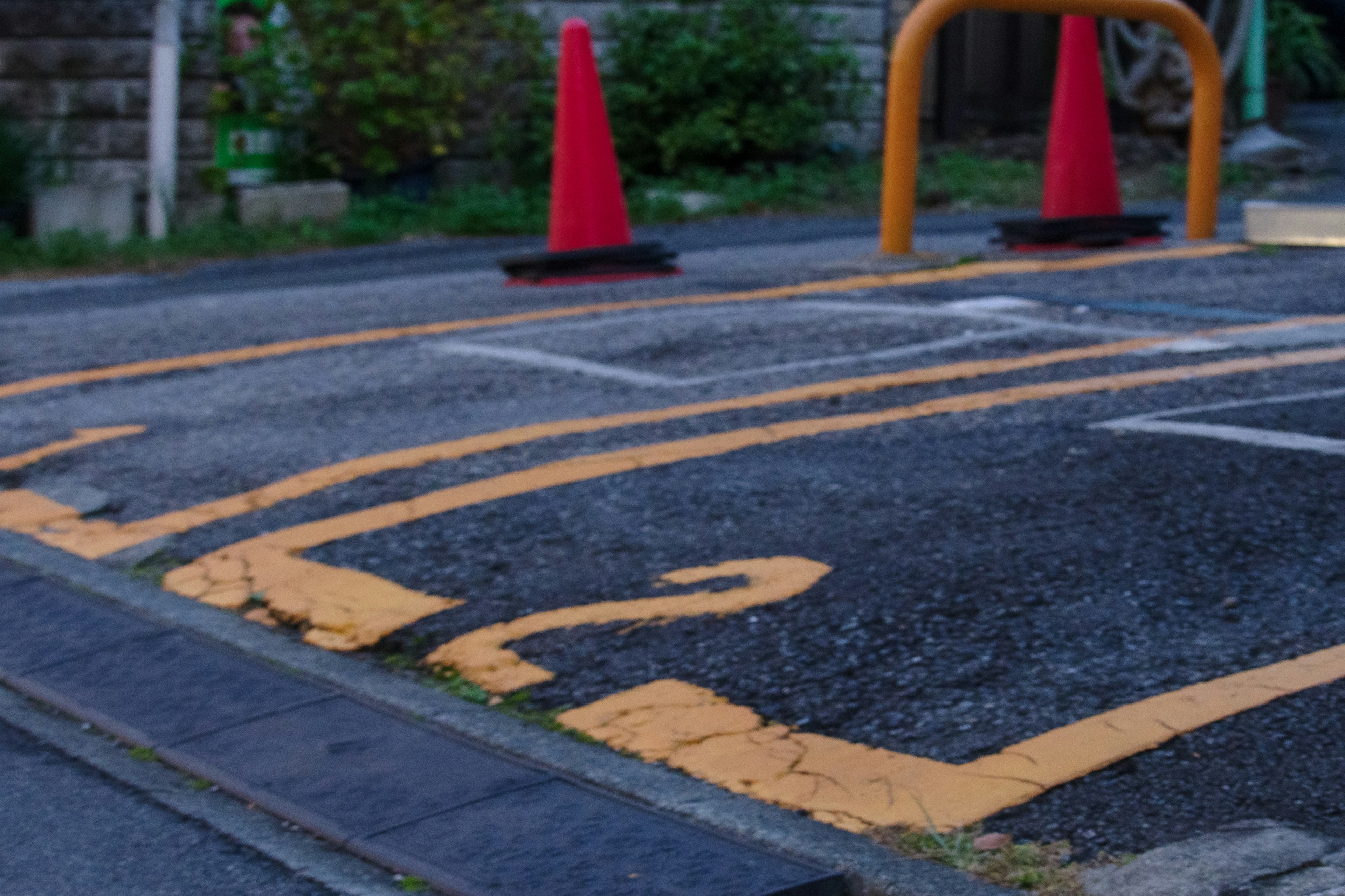 Paved ground with a parking number and red cones standing nearby