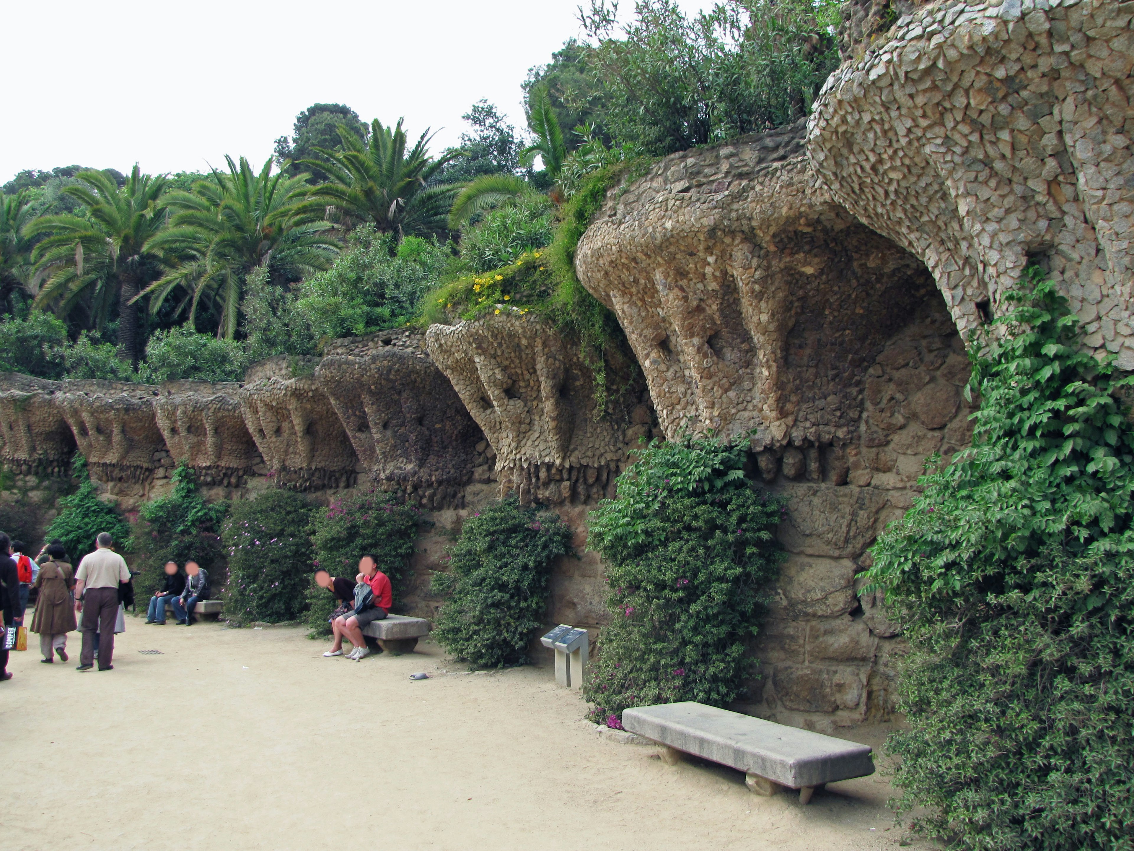 Parque con estructuras de piedra y vegetación a lo largo de un camino