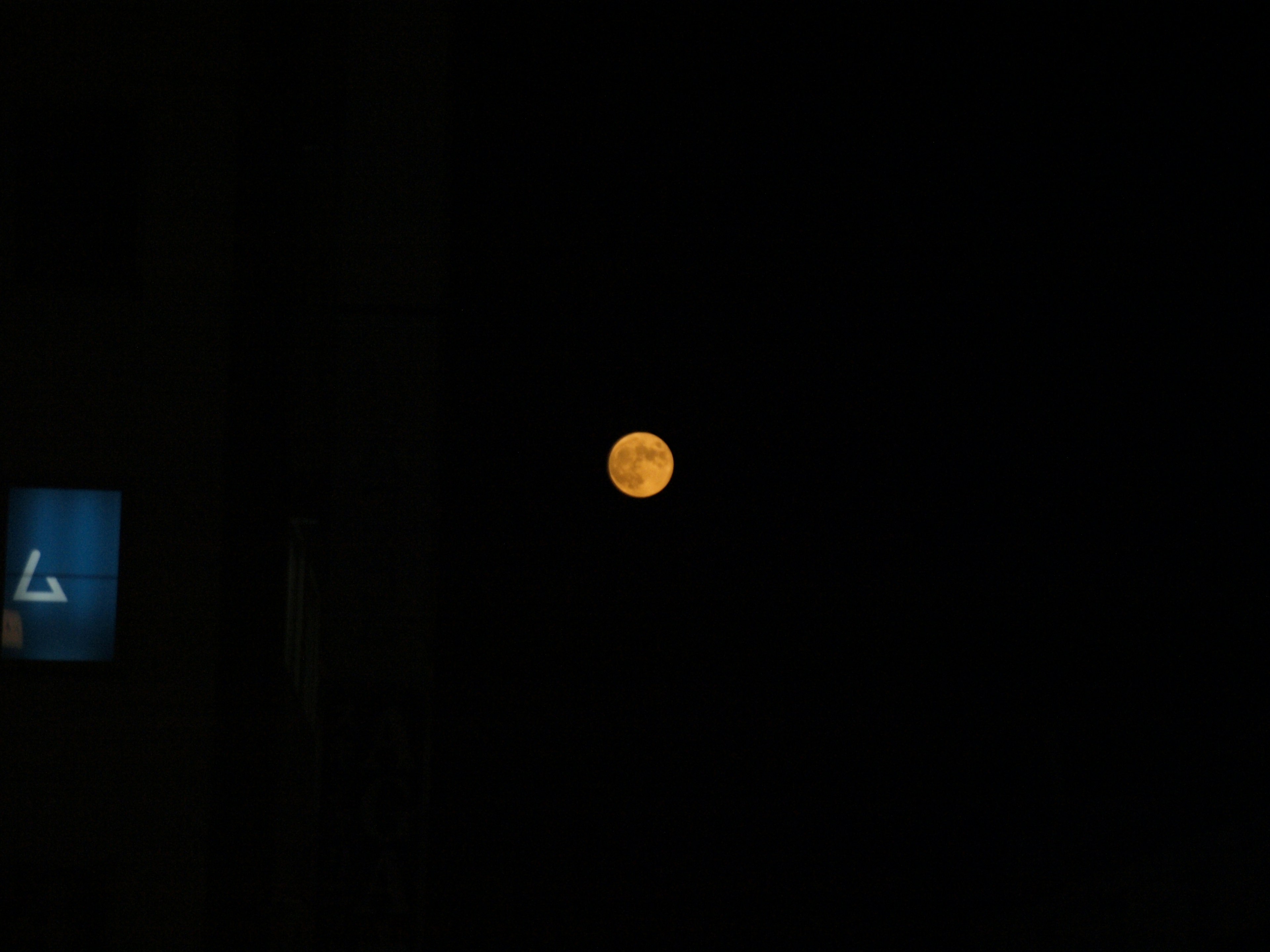 Orange full moon in the night sky