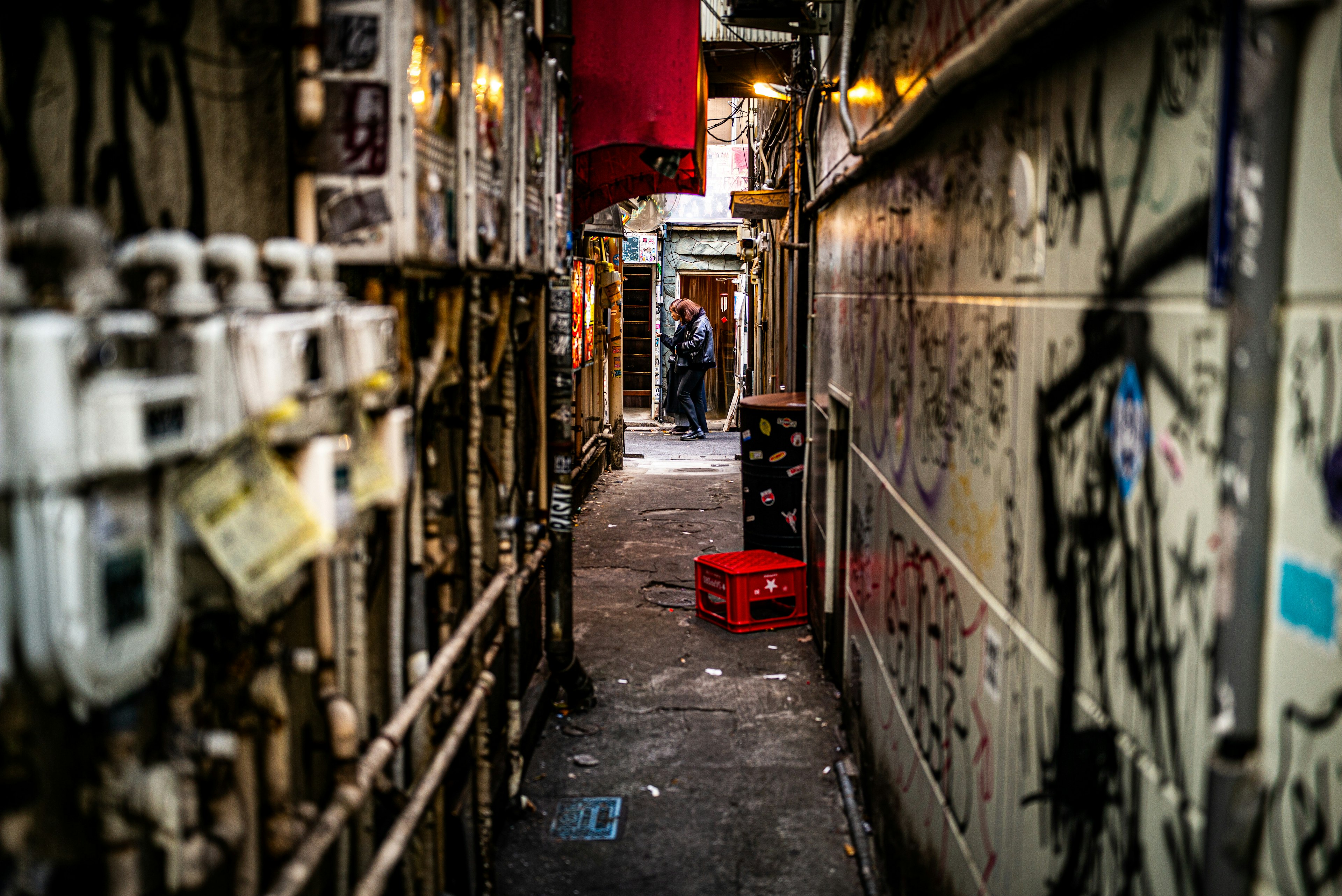 狭い路地にあるグラフィティと配管のある風景