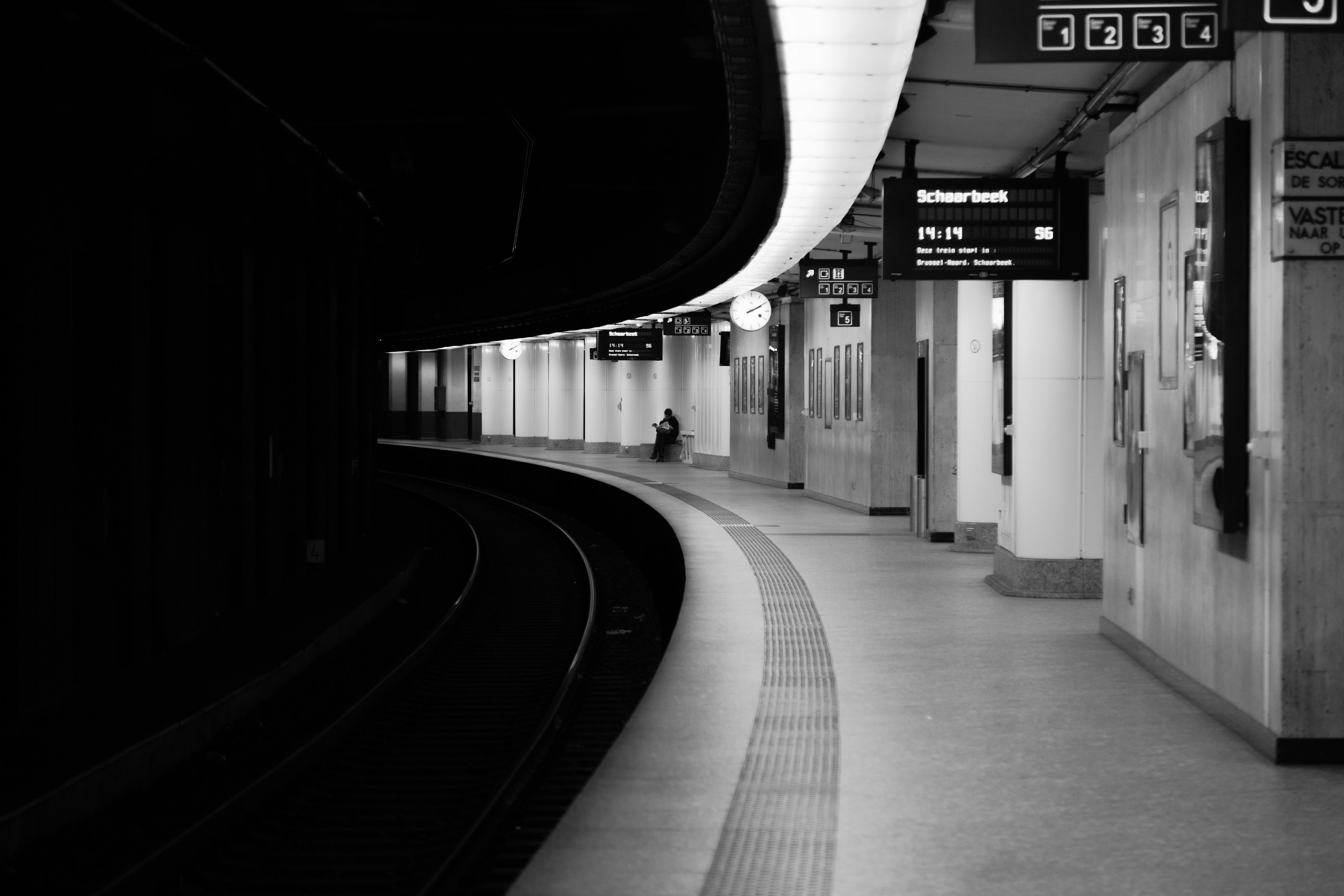 Black and white subway station platform Curved tracks and dim lighting