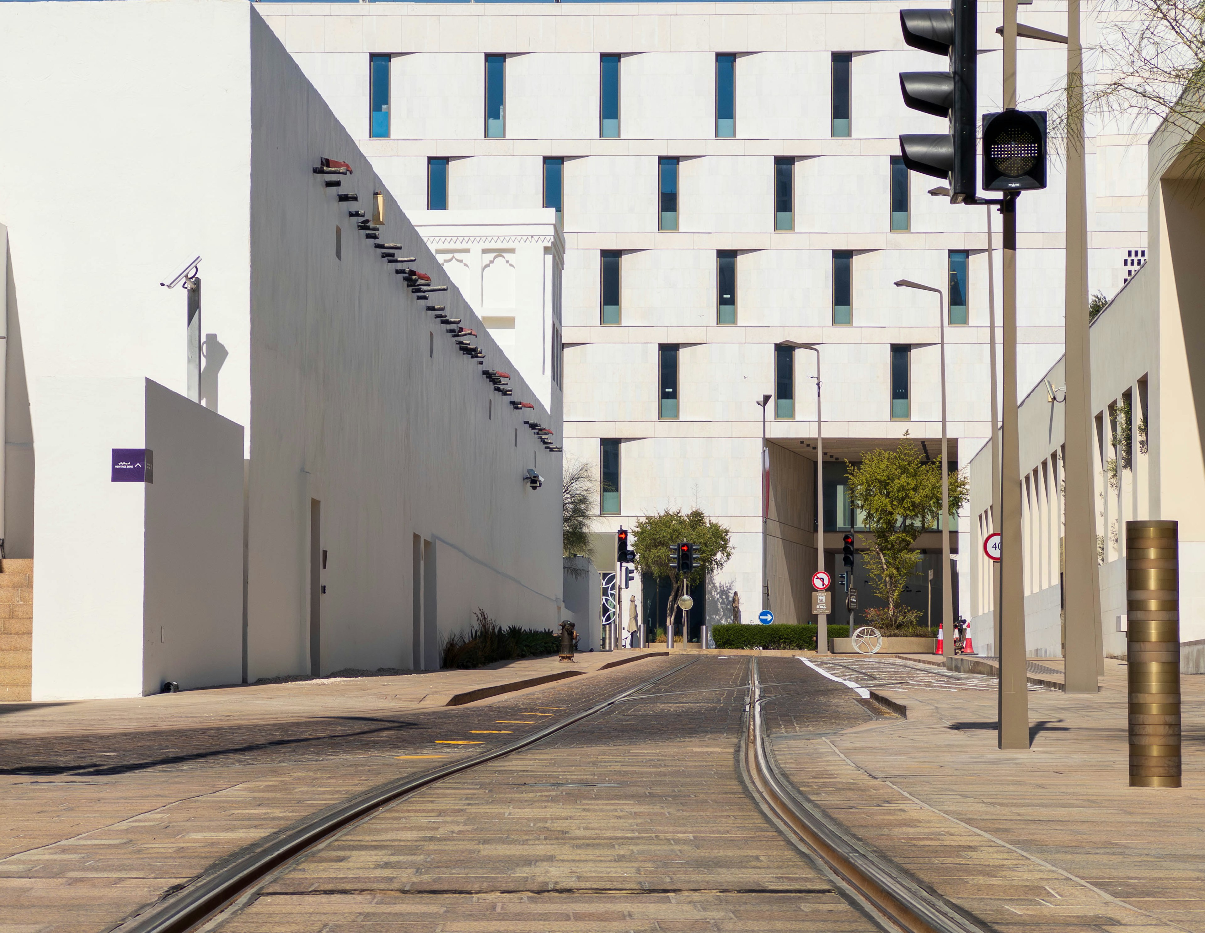 Urban scene featuring a white building and tram tracks