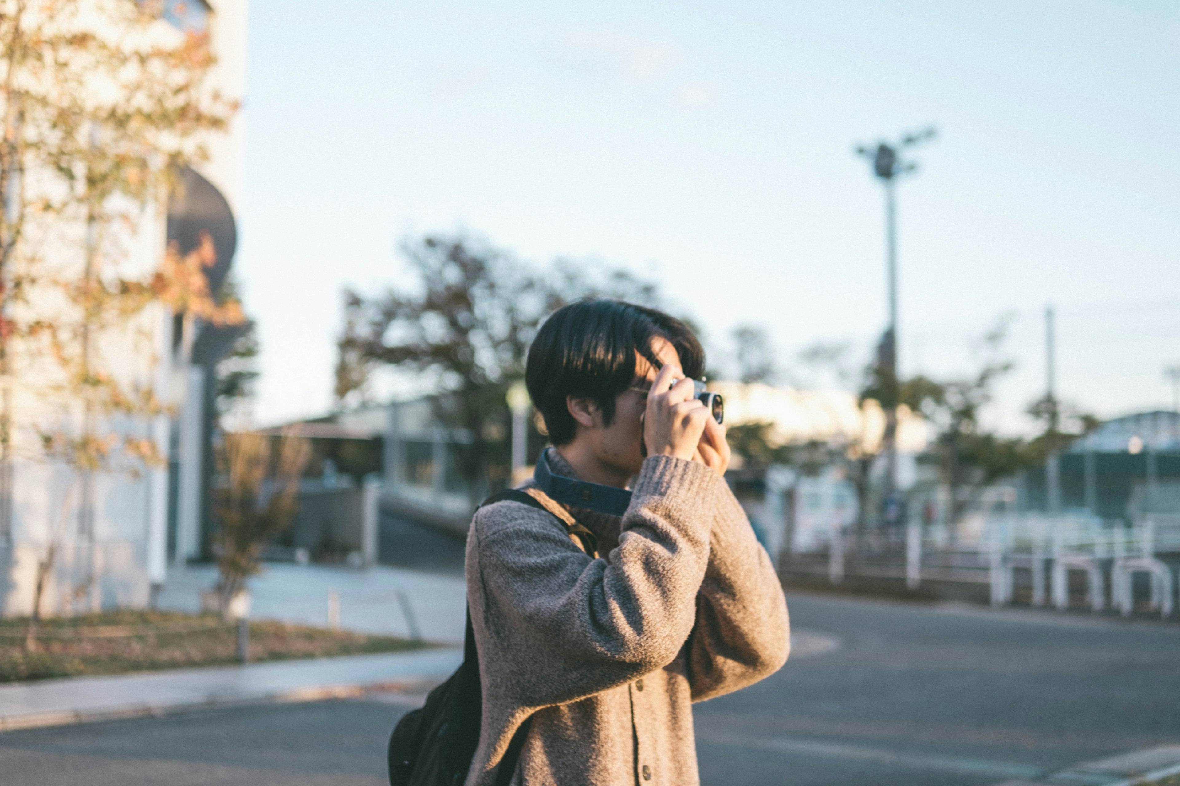 Perfil de un hombre sosteniendo una cámara con paisaje otoñal